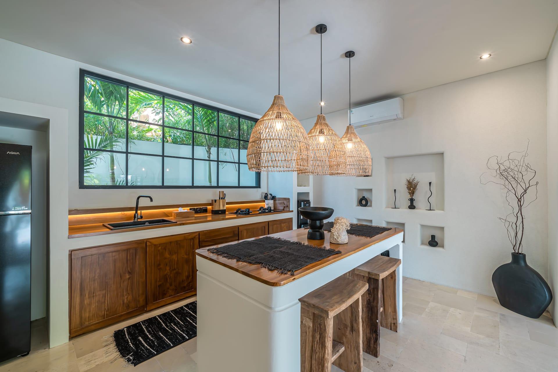 Kitchen with timber cabinetry, a dark-topped island and a long steel-framed window over the worktop