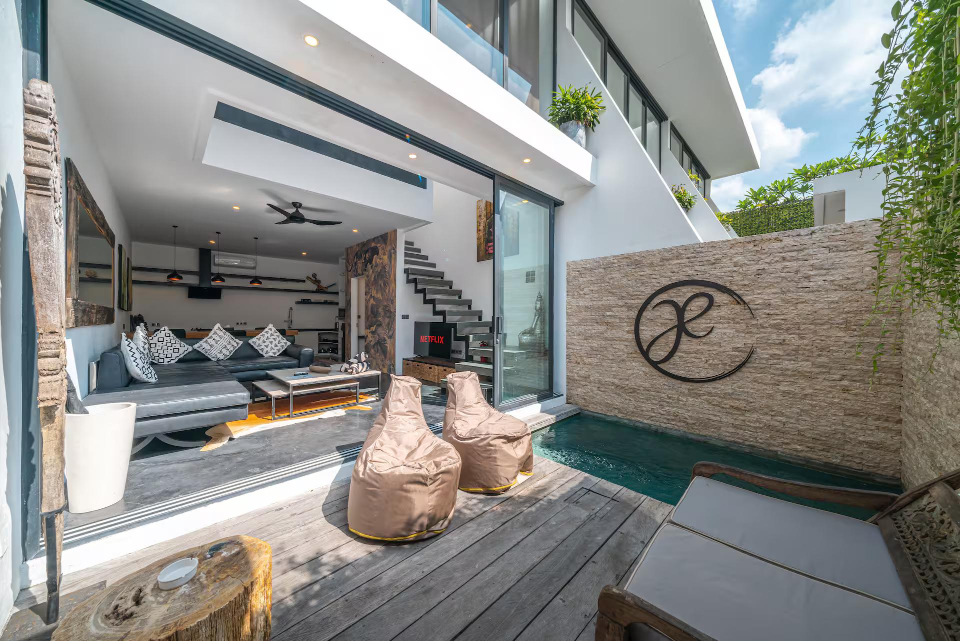 Beanbags and a rattan daybed on the deck beside the plunge pool at Loft Ludo 3
