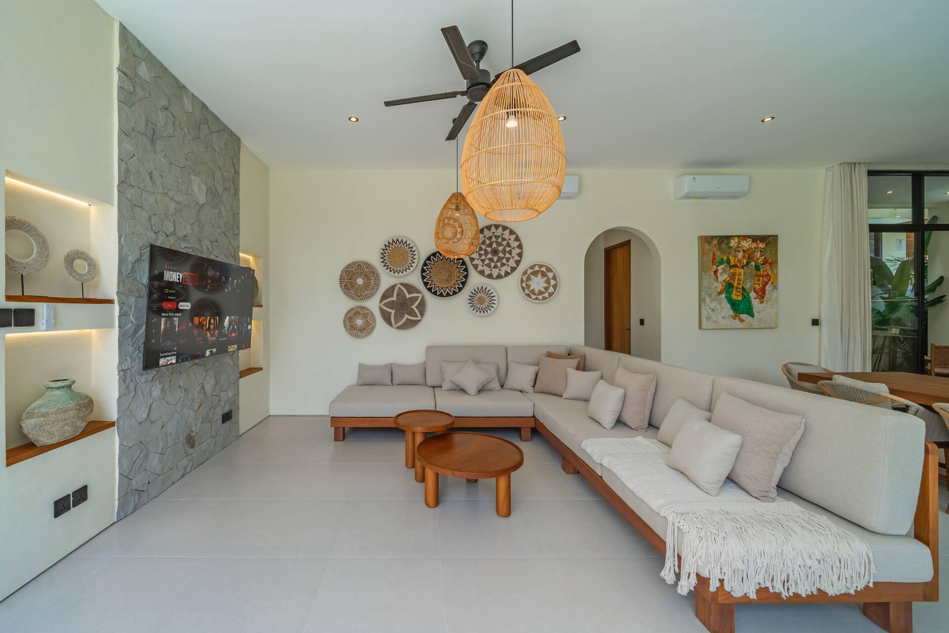Villa Ba'an living room with woven wall plates, a deep L-sofa and an arched doorway