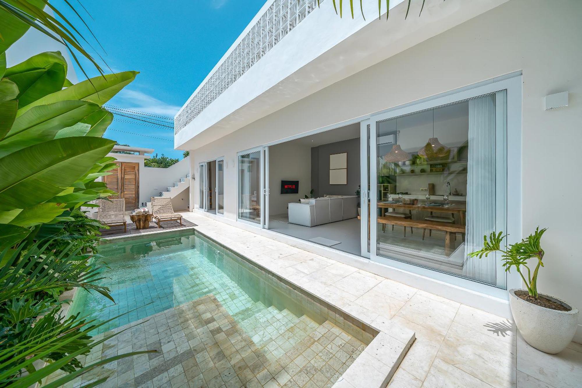 The narrow pool at Villa Gajah running the length of the courtyard beside the living-room glass