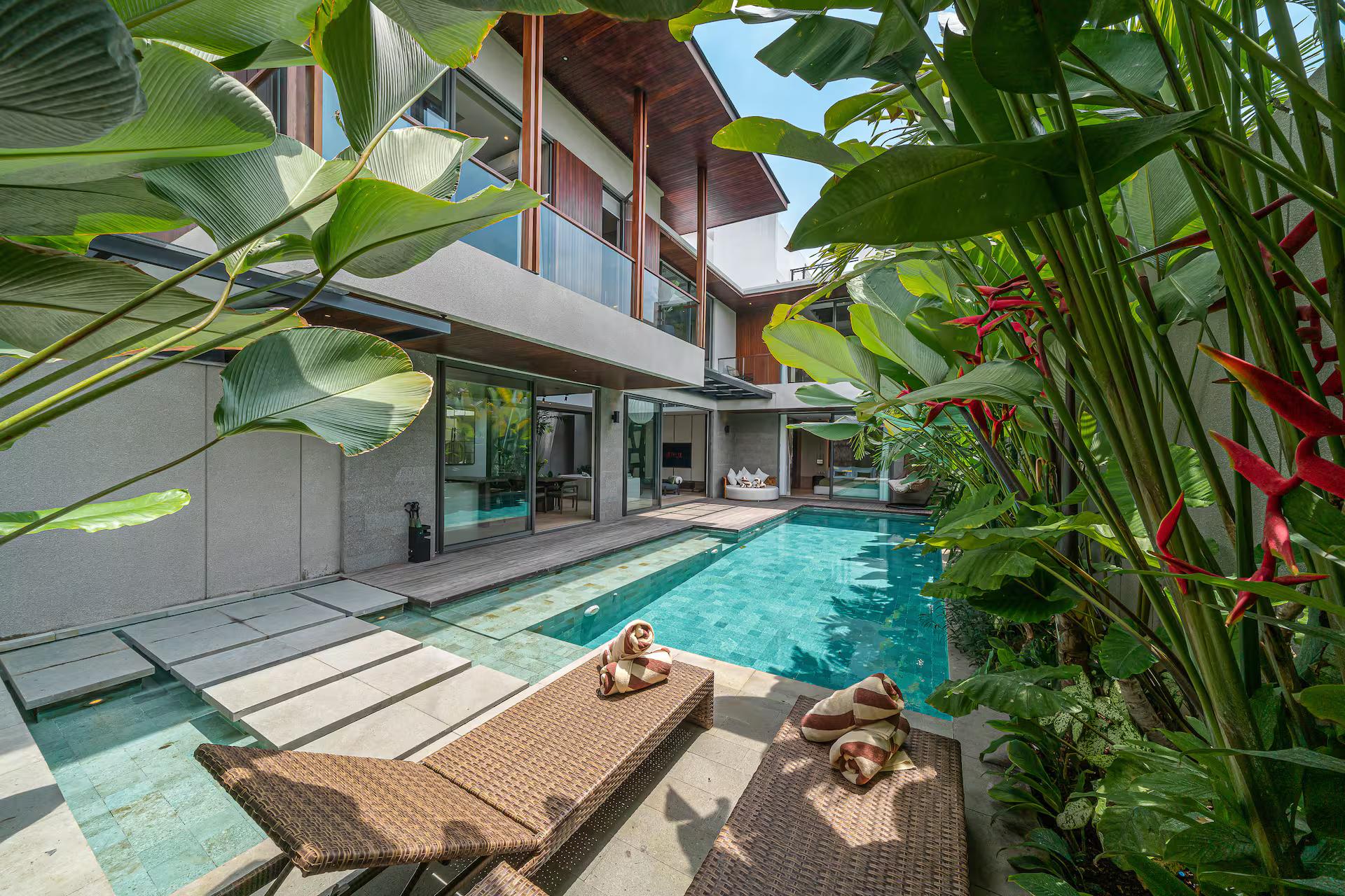 Green-tiled pool at Villa Akar & Daun, heliconia and banana palms crowding the deck