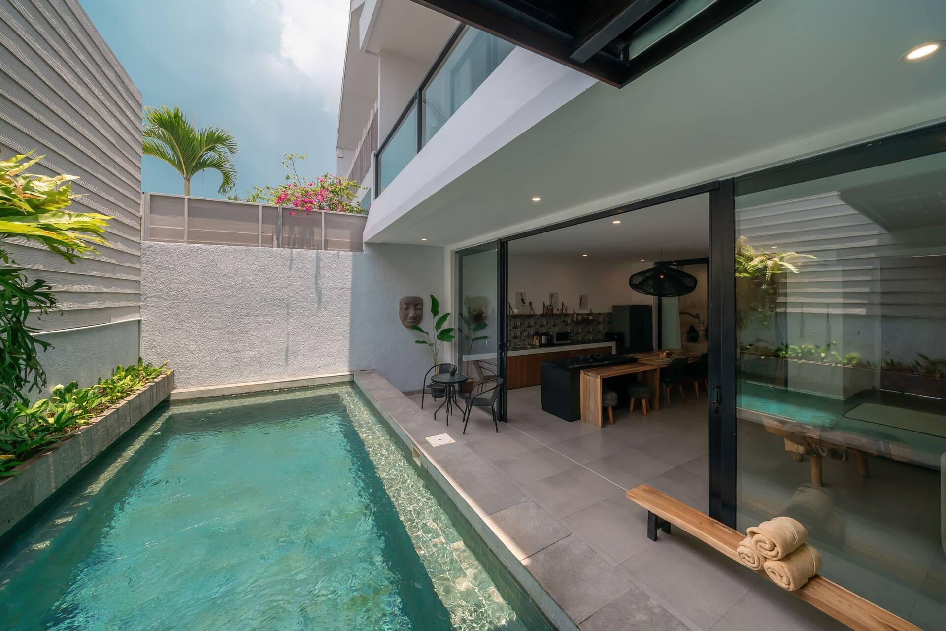 Villa Athalla's lap pool running the length of the courtyard beside the open living pavilion