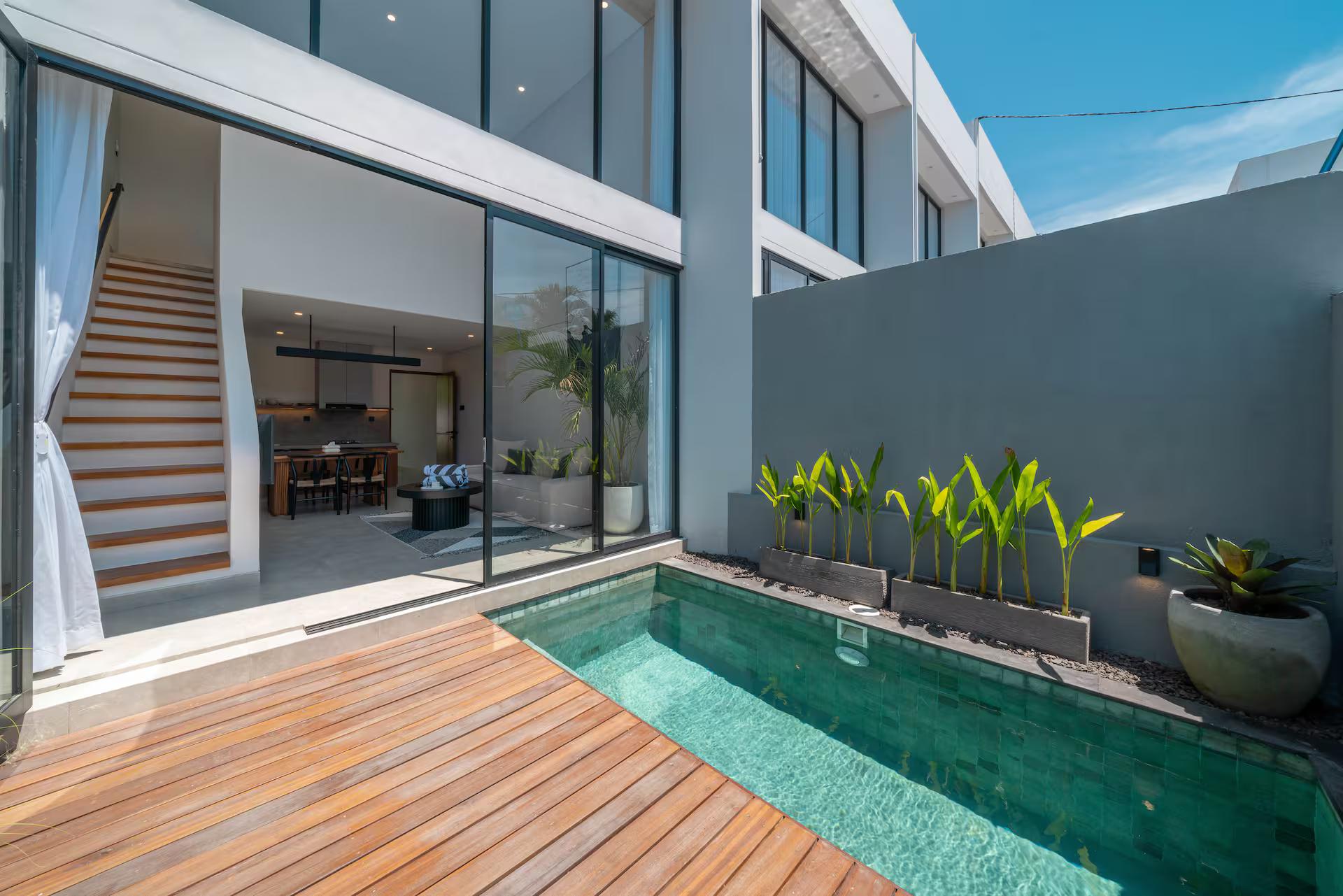 The green-tiled plunge pool and teak deck at Sadila Estate 17, glass sliders folded open