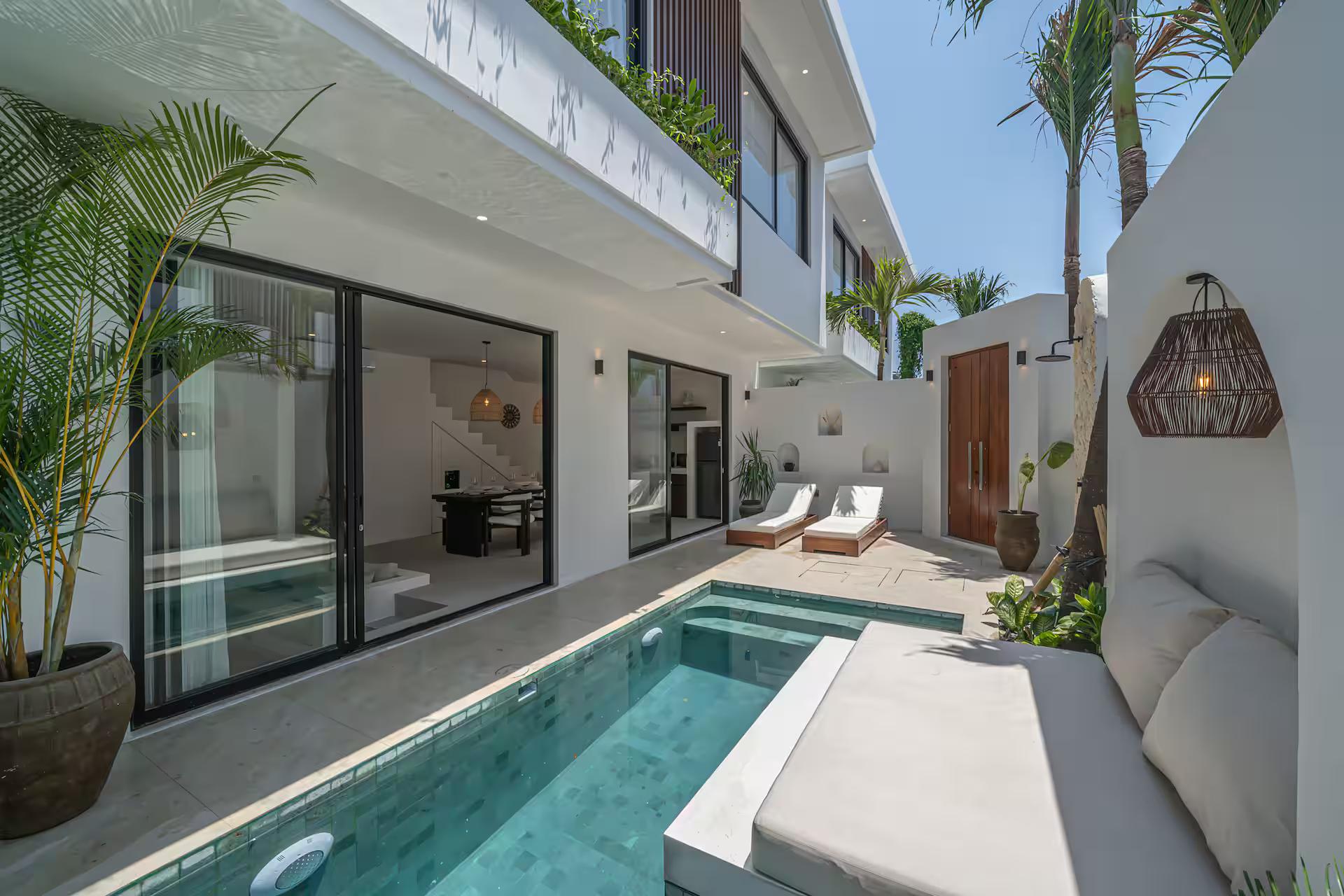 The green-tiled pool at Nova Oasis 3, plaster daybed cantilevered over one corner and loungers beyond