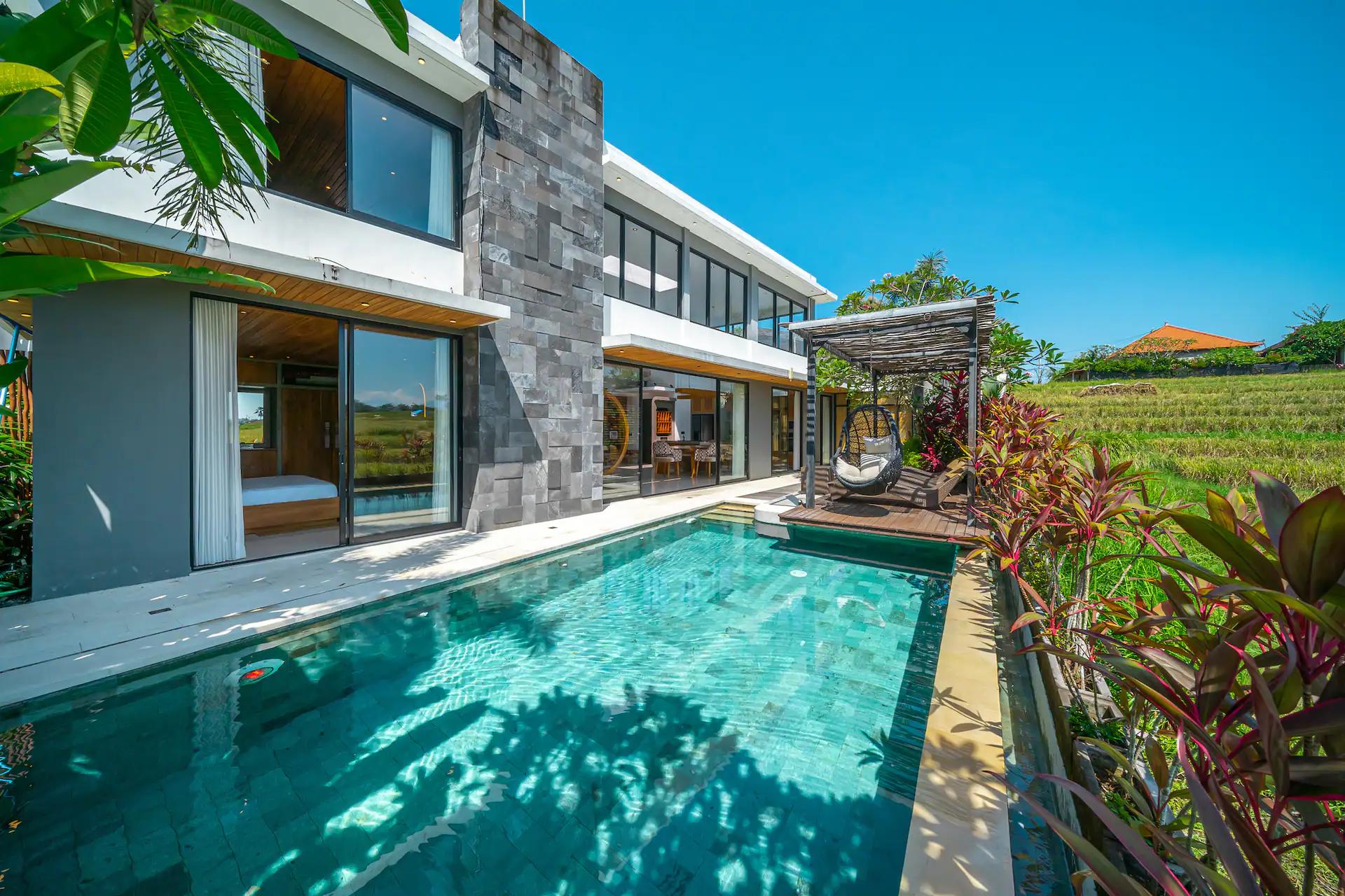 The pool at Villa Asri Nyanyi running the length of the house, rice fields on the far bank