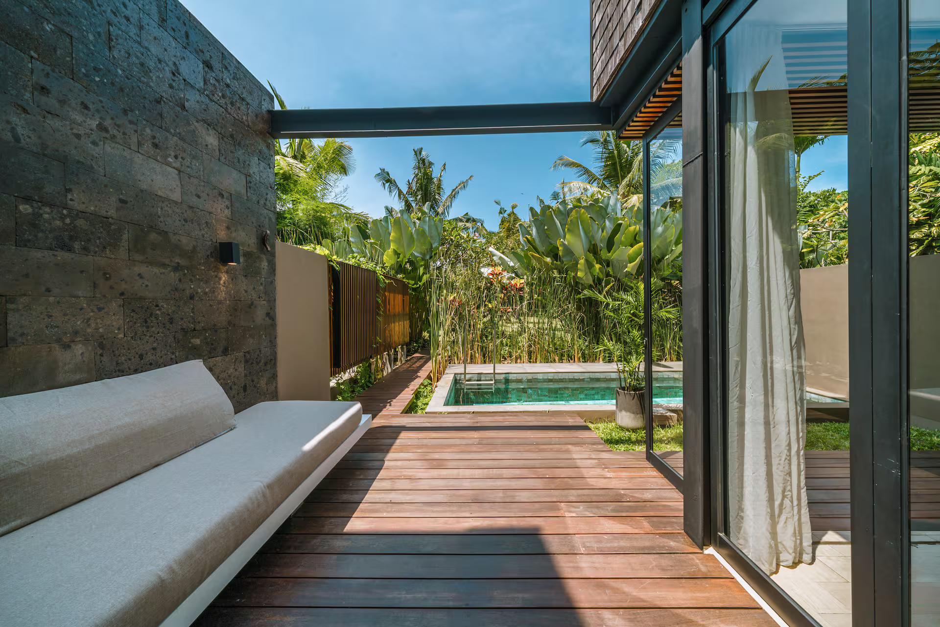 Built-in daybed on the hardwood deck looking down the length of the pool to the garden wall