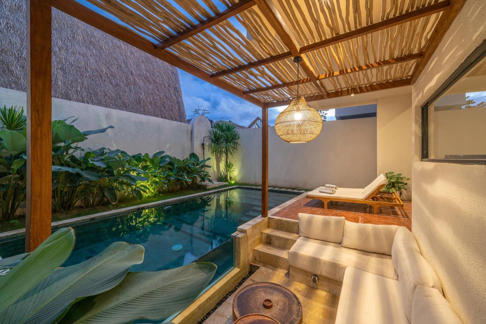 Bamboo-and-timber pergola shading the poolside sofa, looking down the length of the water