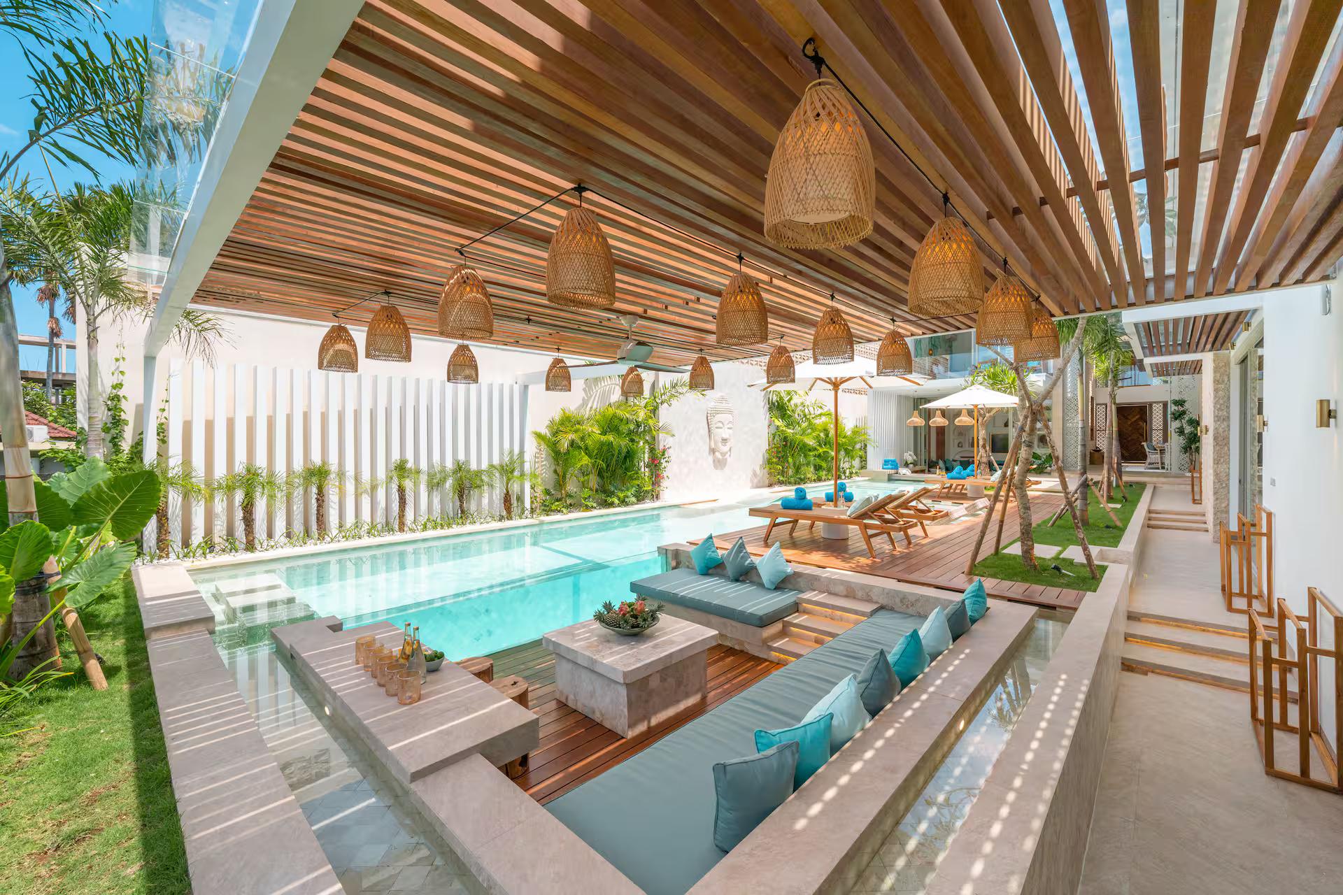 Sunken poolside seating under a slatted timber ceiling hung with woven rattan pendants