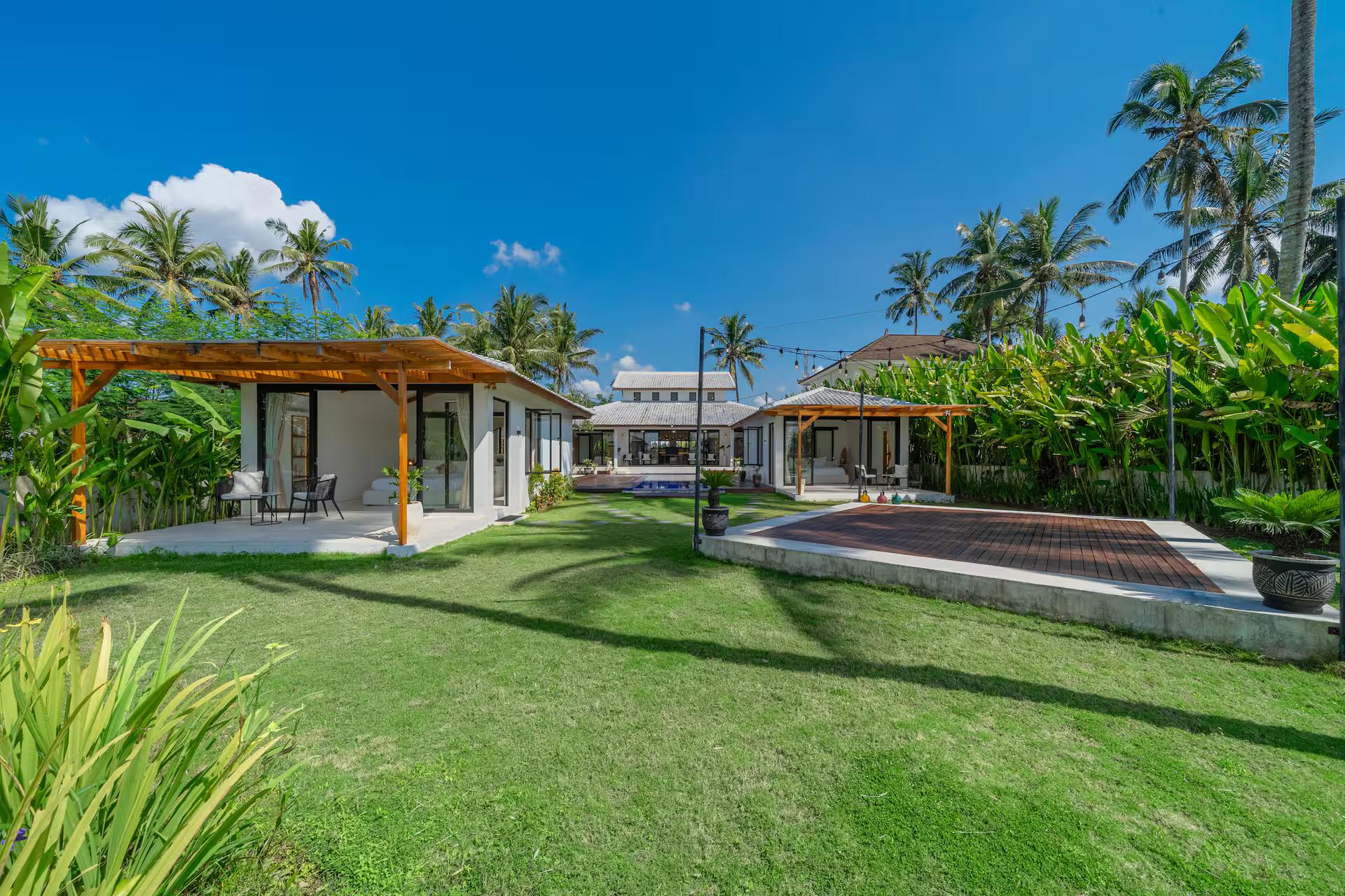 Lawn running from the timber pergola pavilion down towards the rice fields beyond the pool