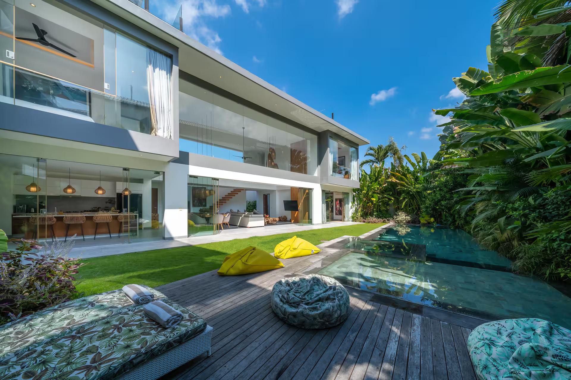 Pool, timber deck and lawn along the open ground floor of The Jendela House