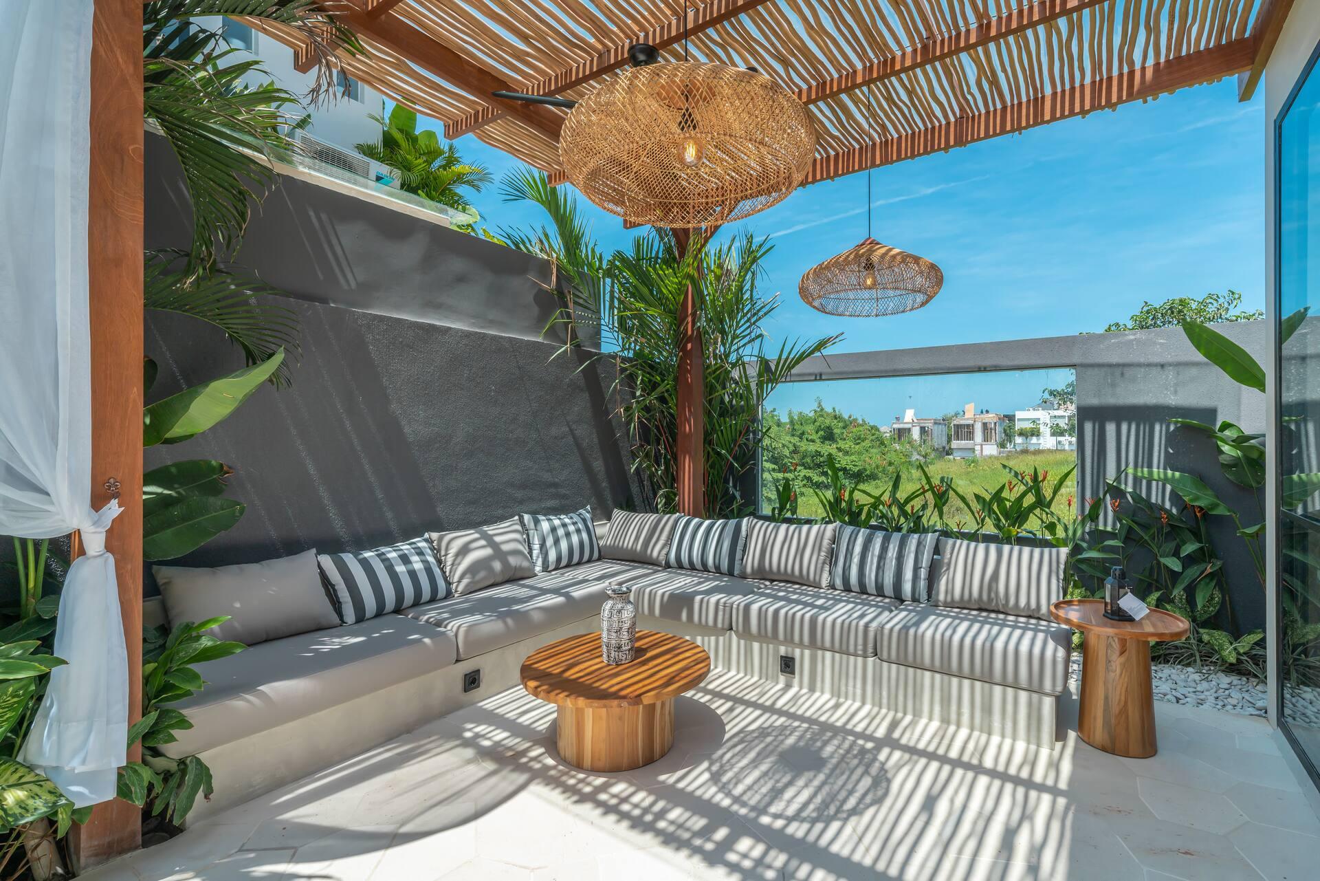 Striped sectional seating under the bamboo pergola on the poolside terrace at Villa Saya