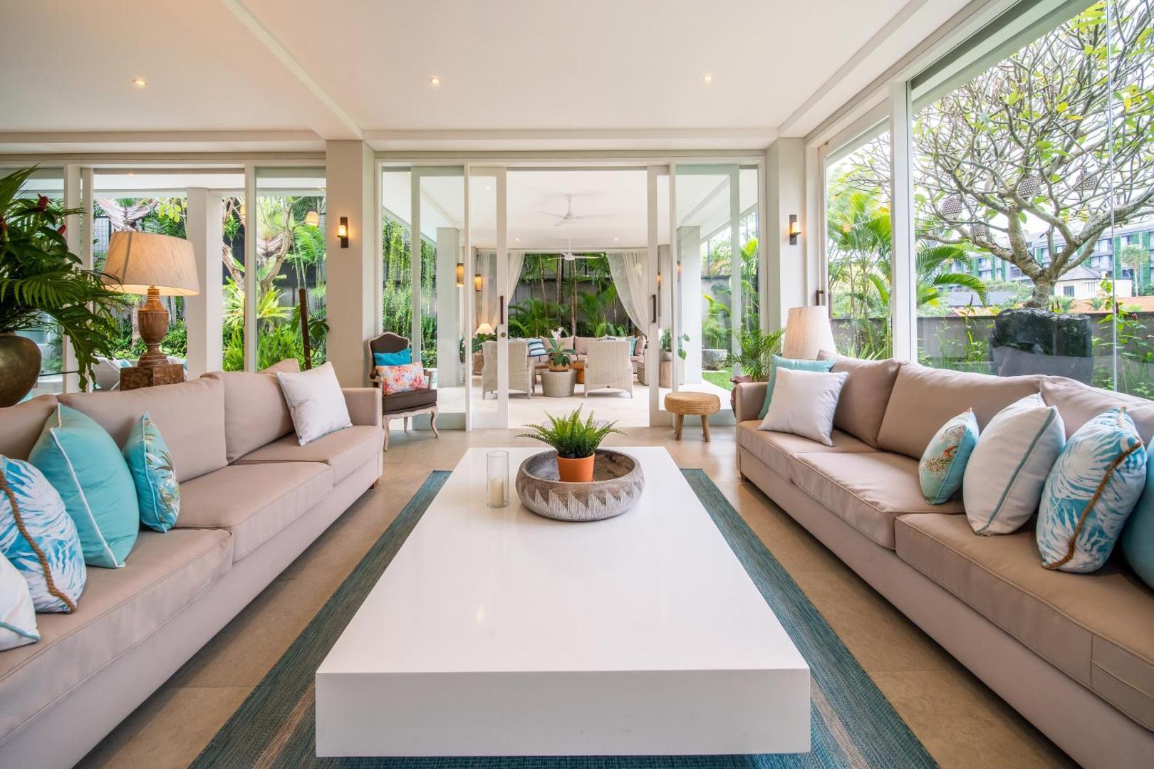 Two long sofas facing a low white table on the open living floor at Villa Sunsara 4