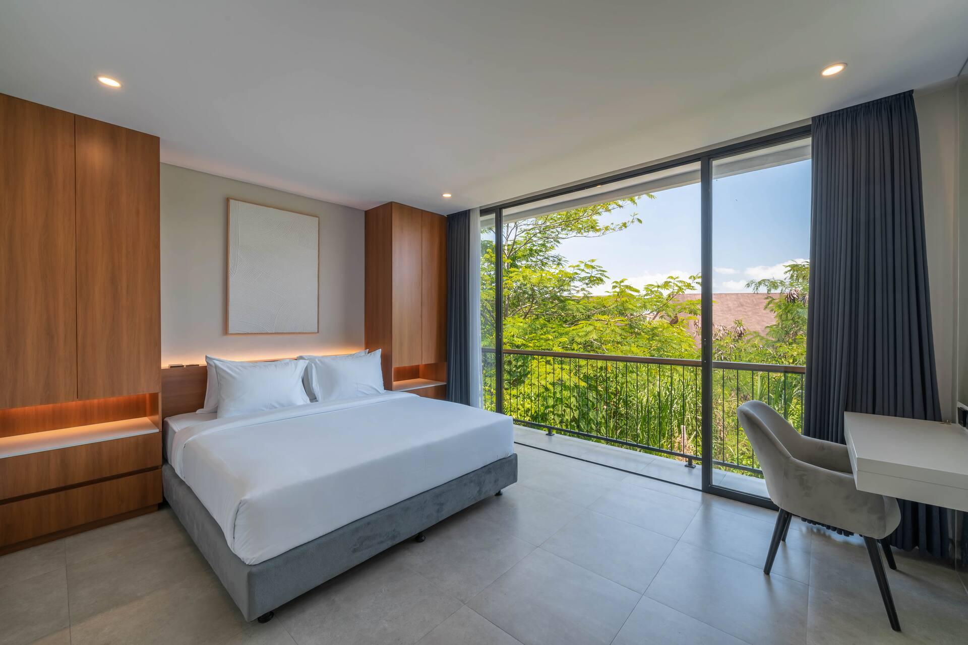 King bedroom at Sadila Estate 17, timber joinery headboard wall and full-height glass to greenery