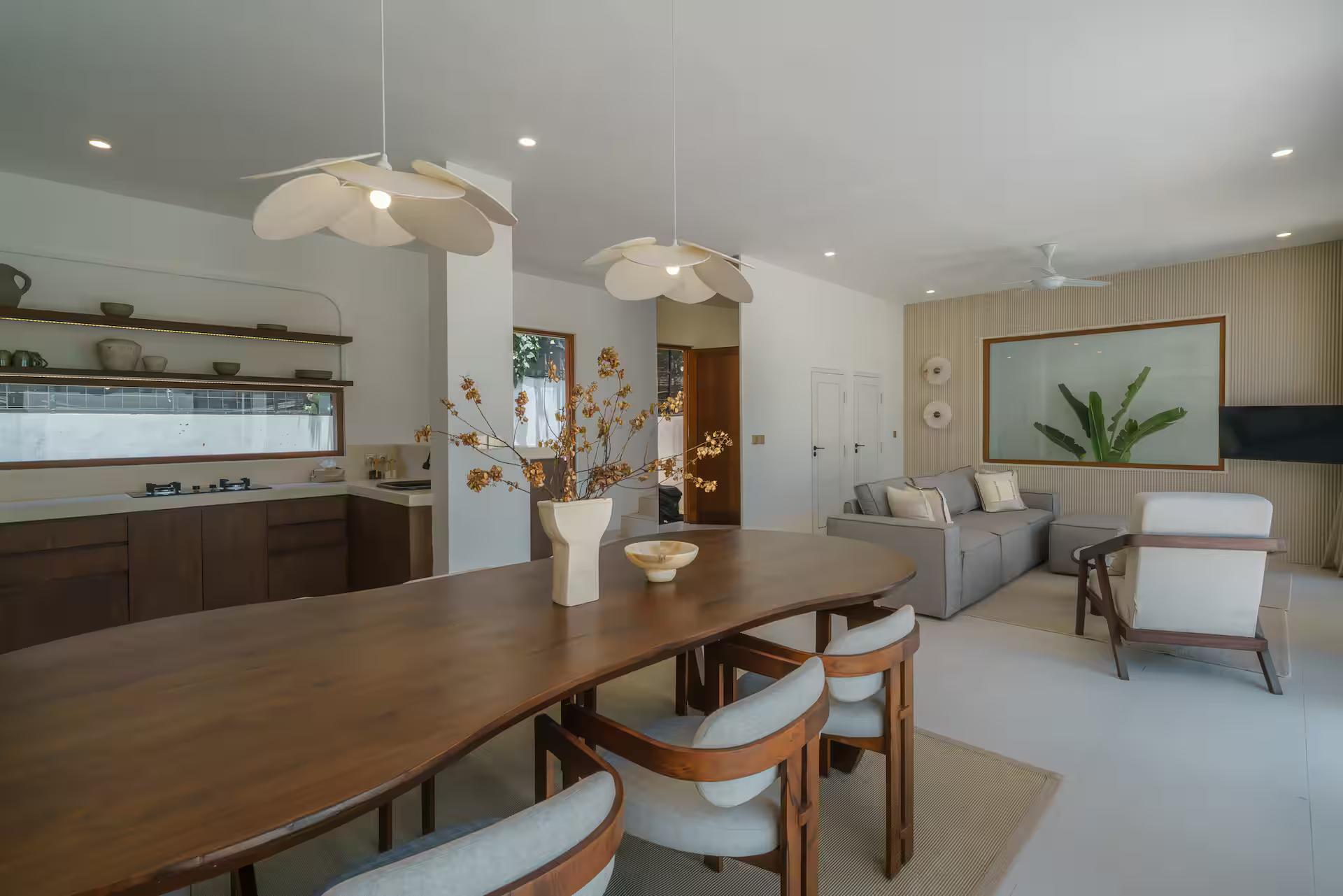 Open-plan ground floor at Villa Umaju: timber dining table, kitchen and lounge in one room
