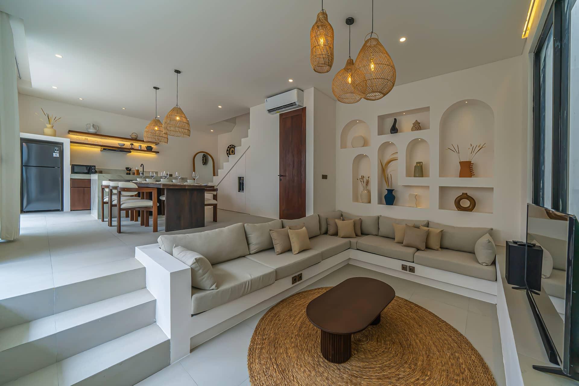 Sunken lounge at Nova Oasis 1, cream banquette around a jute rug below arched display niches