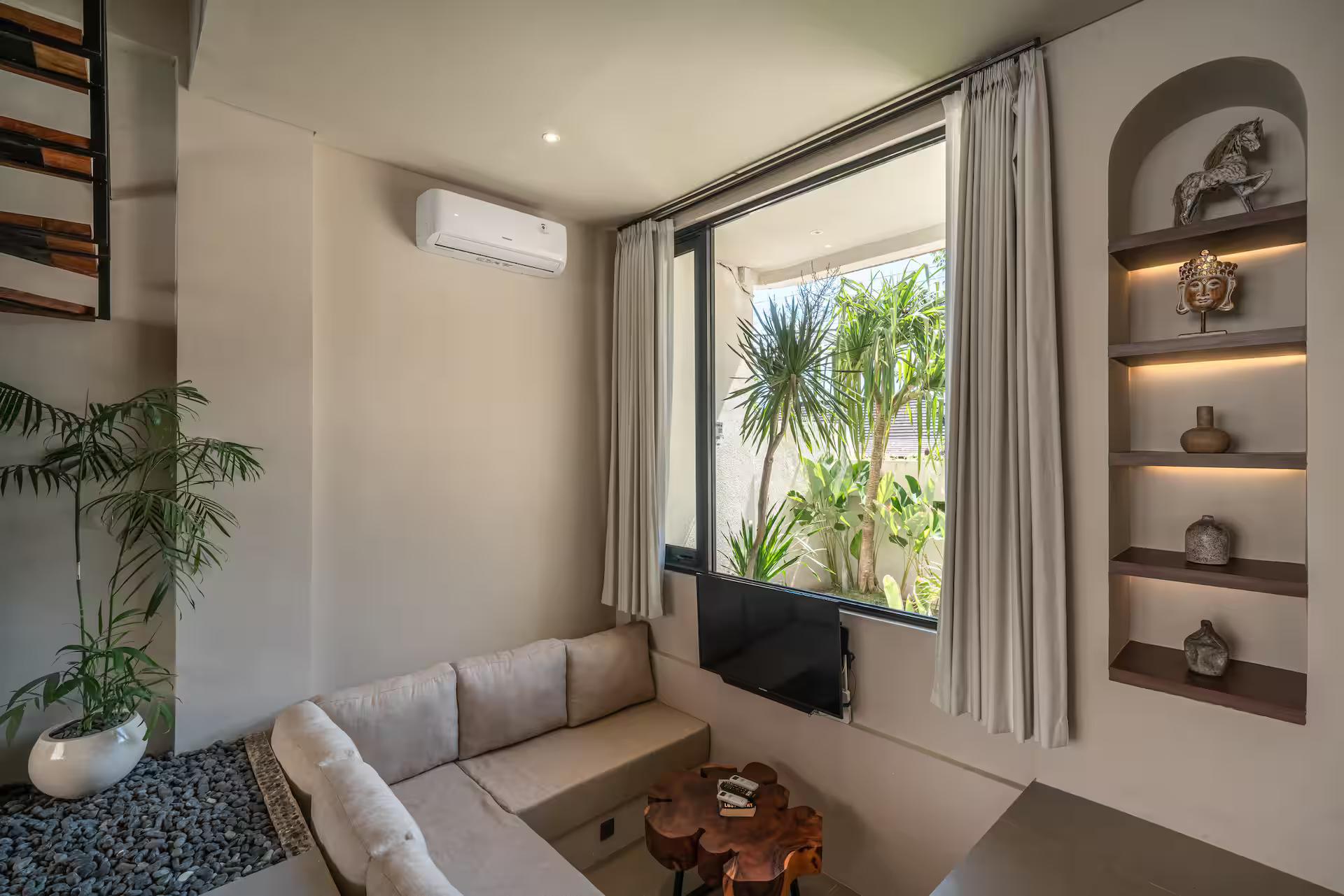 Low white sectional and live-edge timber tables in the double-height living room at Salt Villa