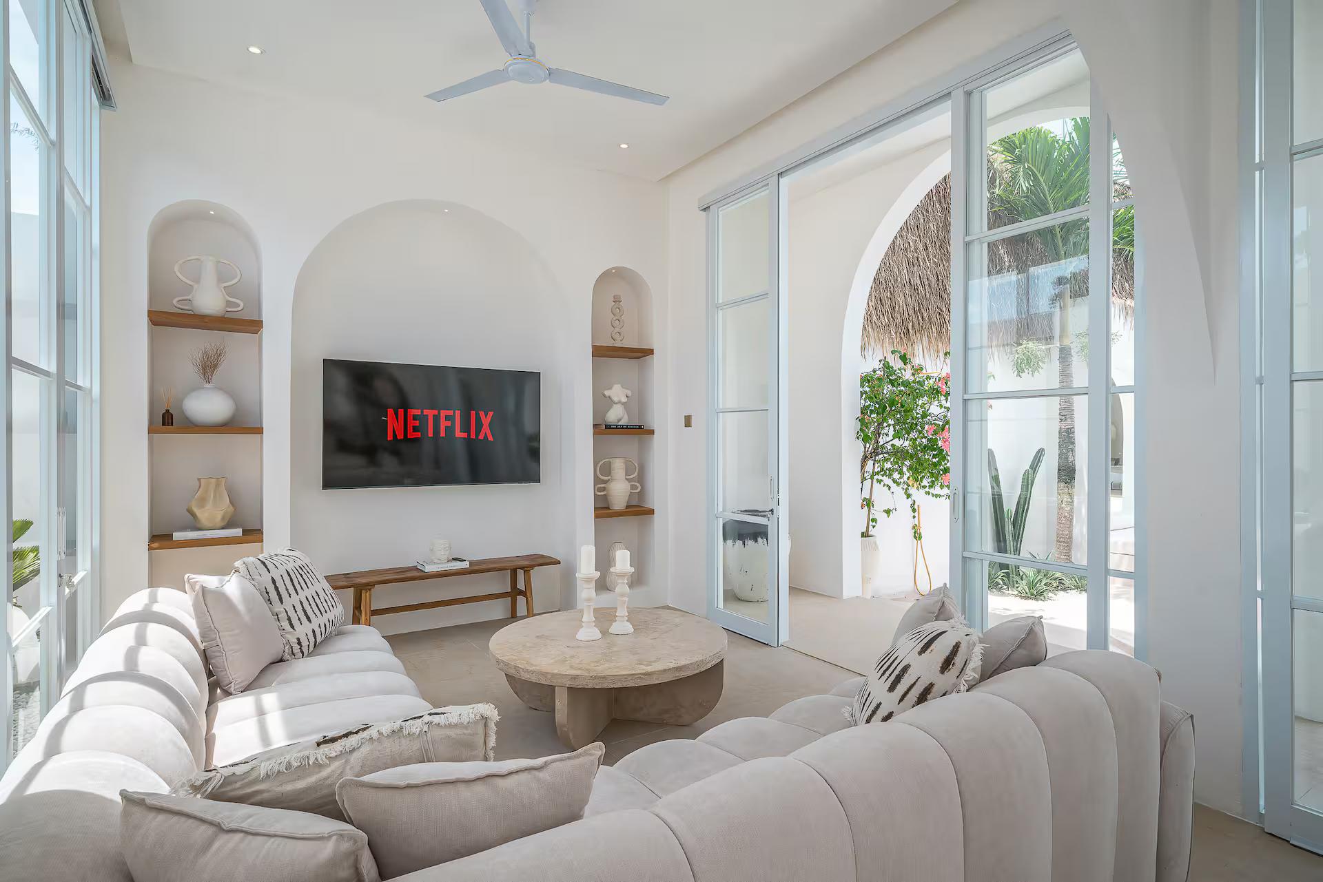 Boucle sectional and round travertine table in the double-height living room at Villa Halo