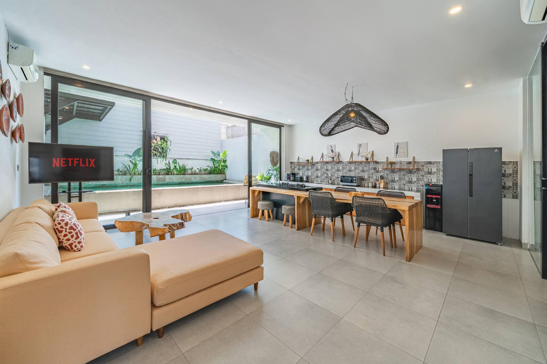 Open-plan living and kitchen at Villa Athalla, a deep sectional sofa facing the glass doors