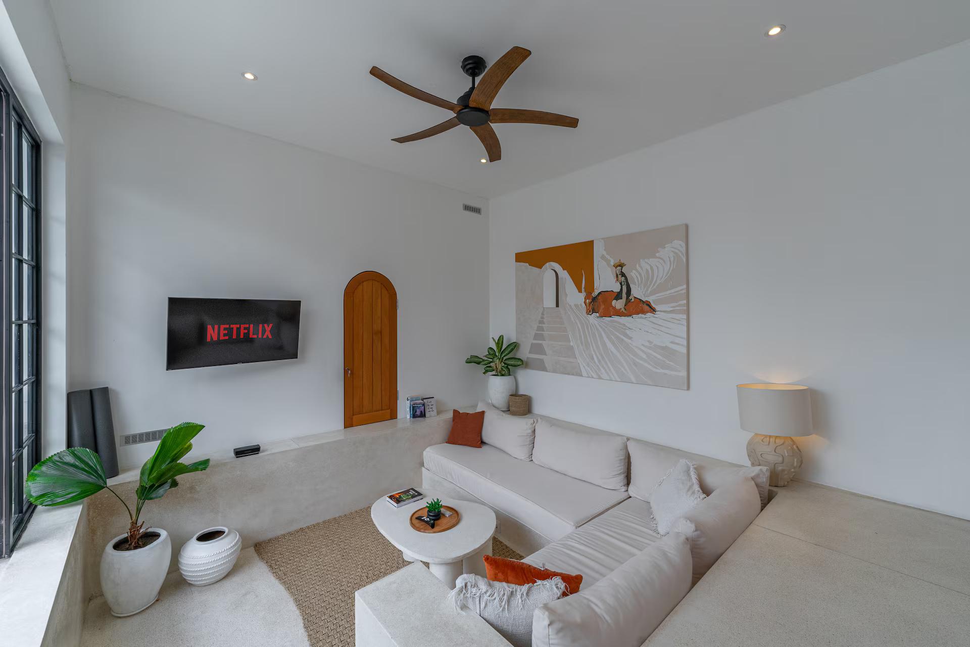 The open living pavilion at Villa Valeria, a built-in plaster sofa facing the wall-mounted smart TV