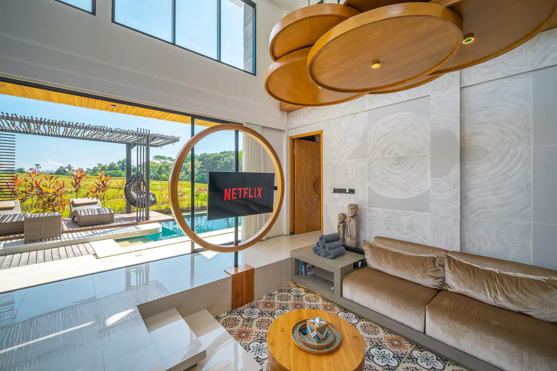 Sunken living room with a putty linen sectional and a television framed in a circle of timber
