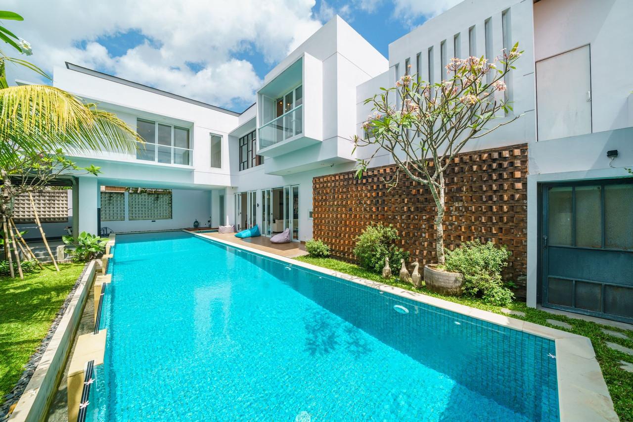 The twenty-metre lap pool alongside the house, brick-lattice screen wall and frangipani