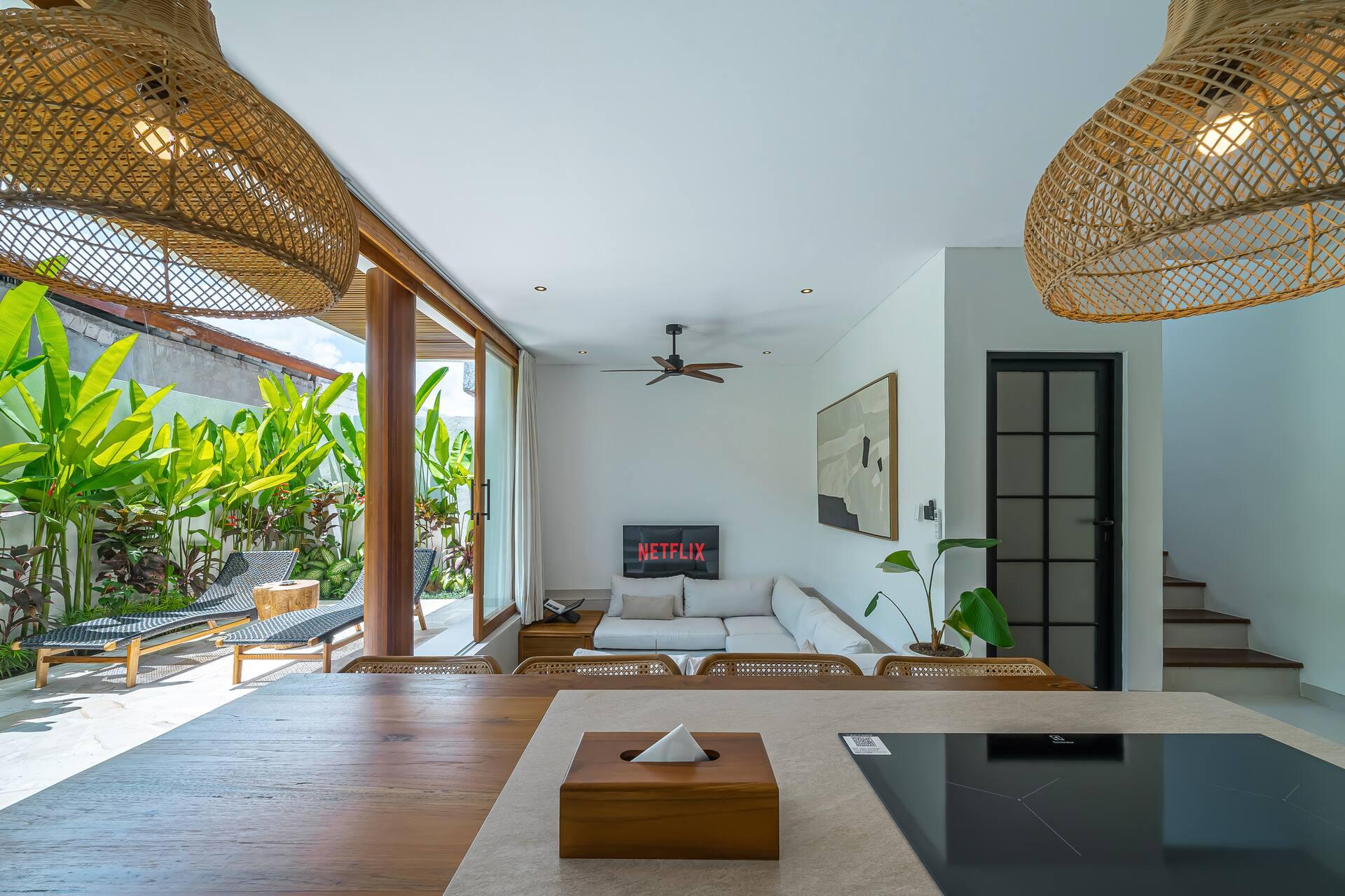 Sunken lounge with a white modular sofa under a ceiling fan, open to the pool terrace