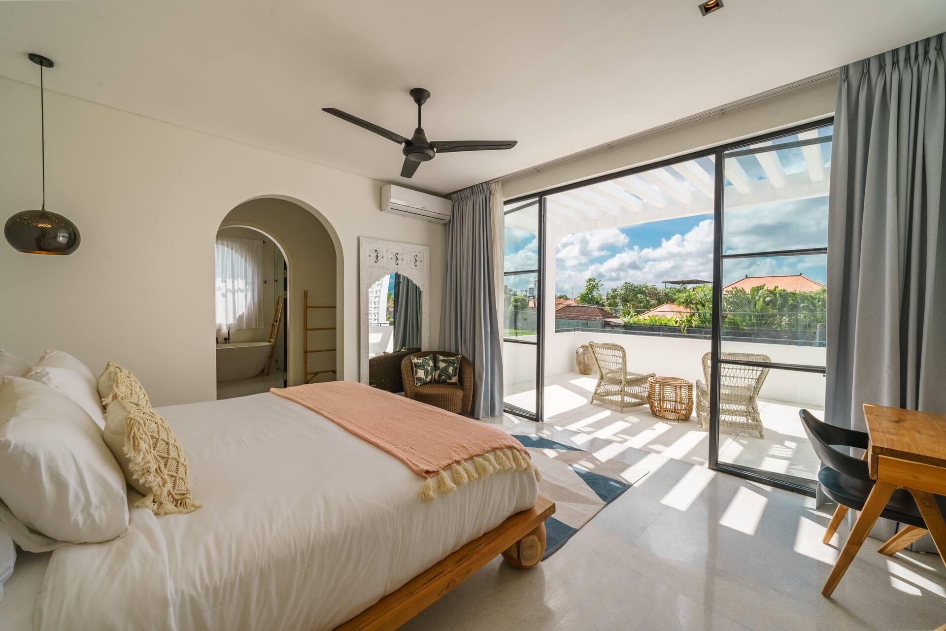 King bedroom at Casa Brezza opening through glass doors onto the pool terrace