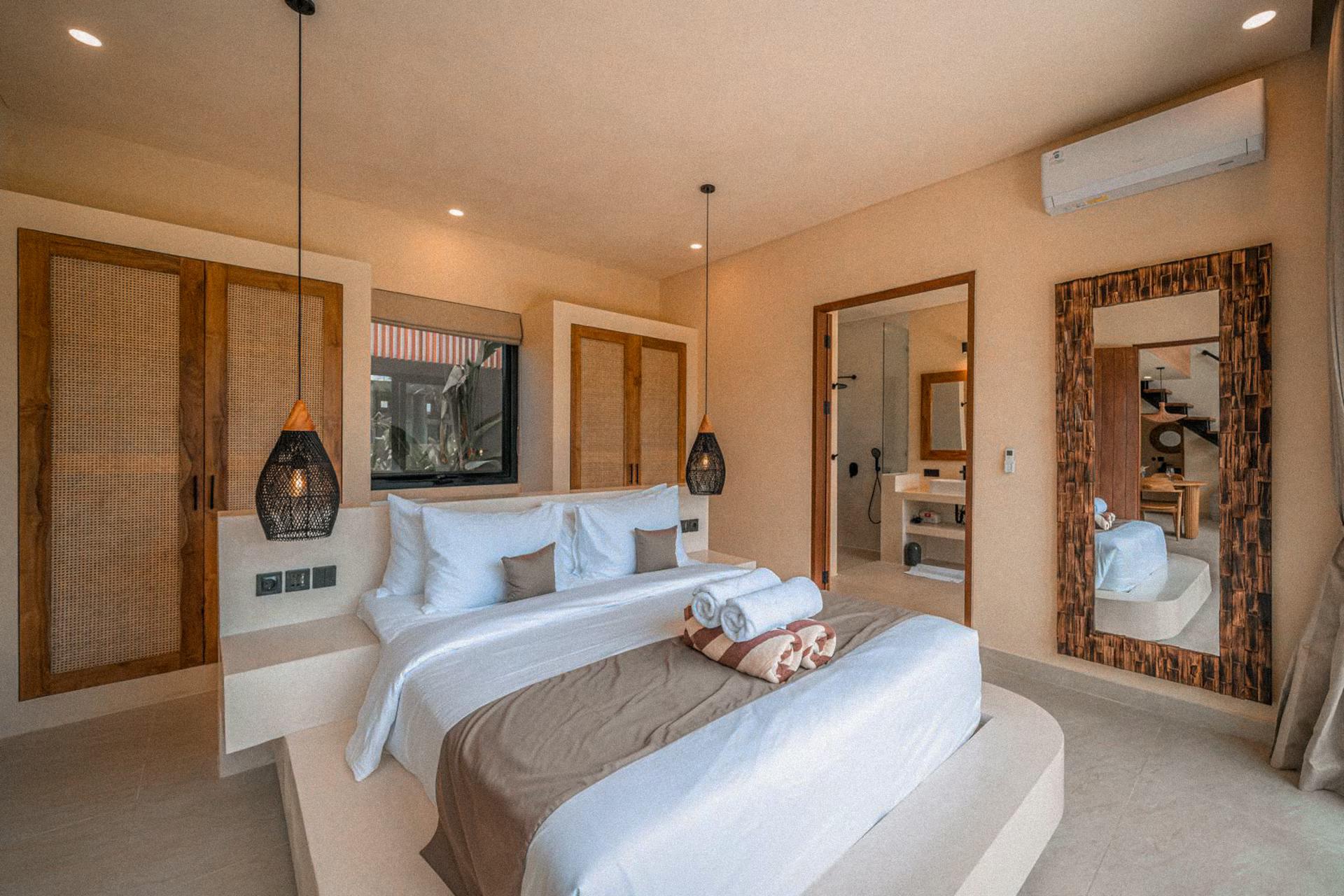 Ground-floor bedroom with woven wardrobe panels, a cane pendant and a tall mirror