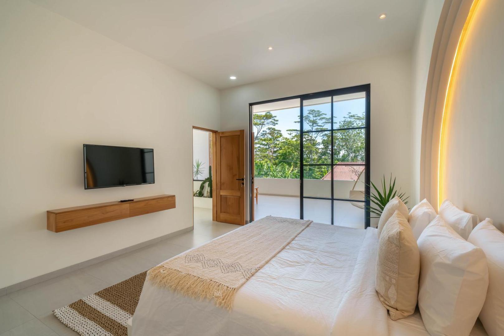 Bedroom with a wall television on a floating timber ledge and doors to the terrace