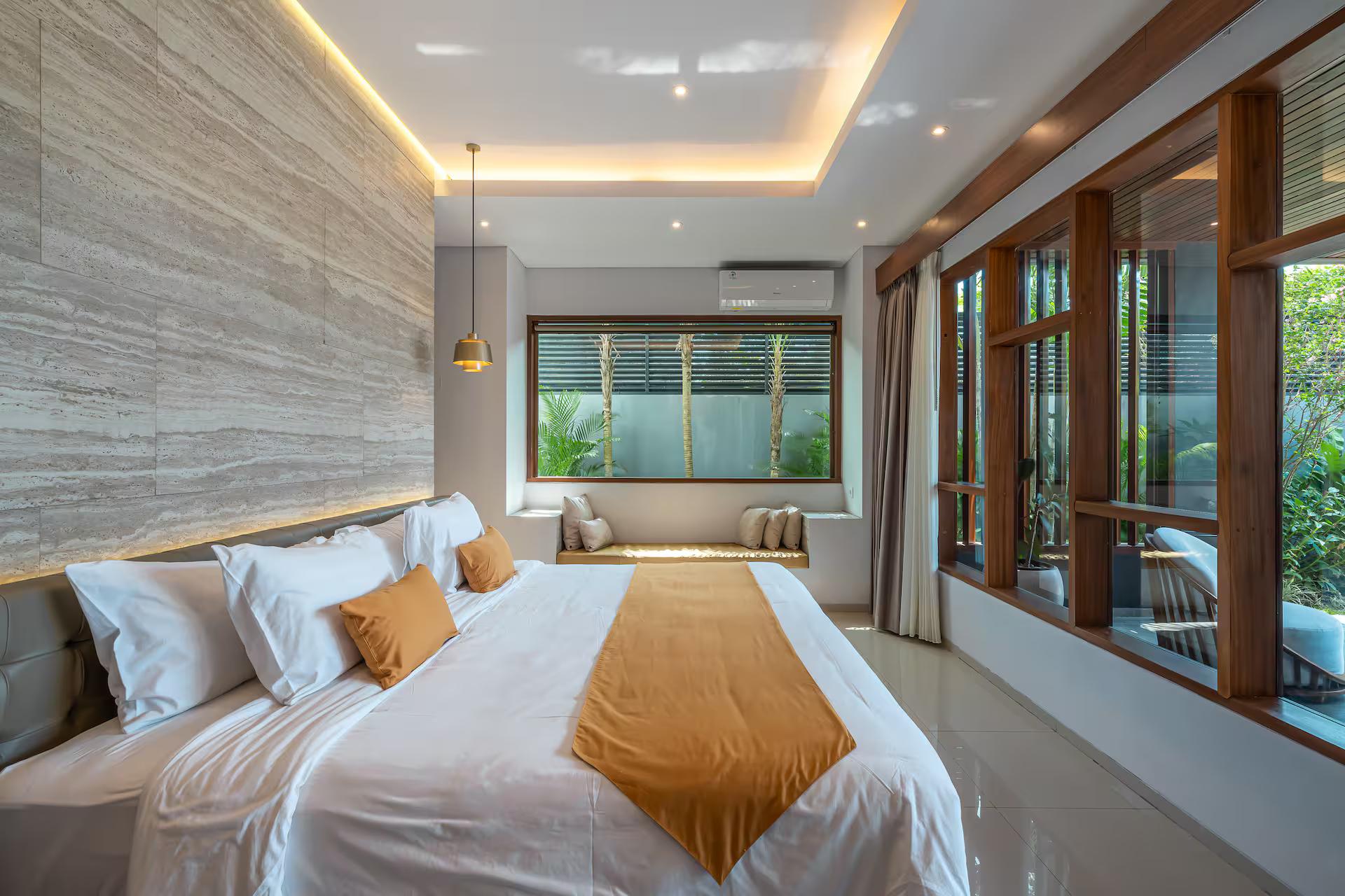 King bedroom in pale travertine with a mustard runner and windows to the garden