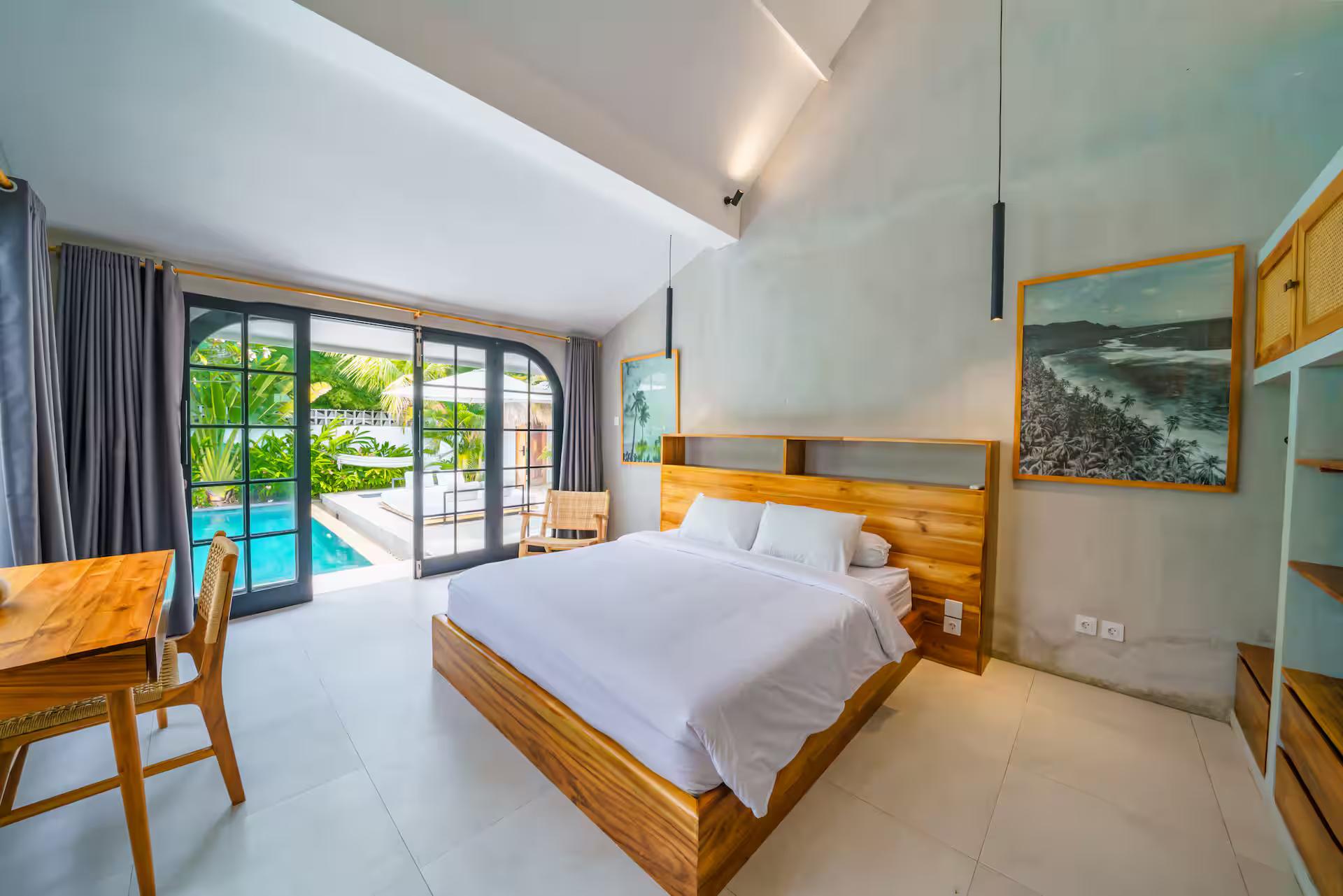 King bedroom at Villa Mellow with a timber platform bed and doors open to the pool deck