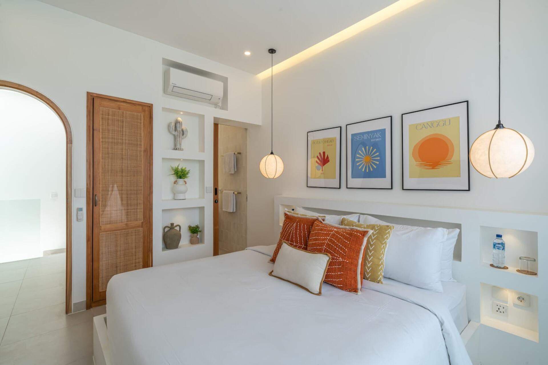 King bedroom at Villa Polanco with lit arched niches and framed Bali prints