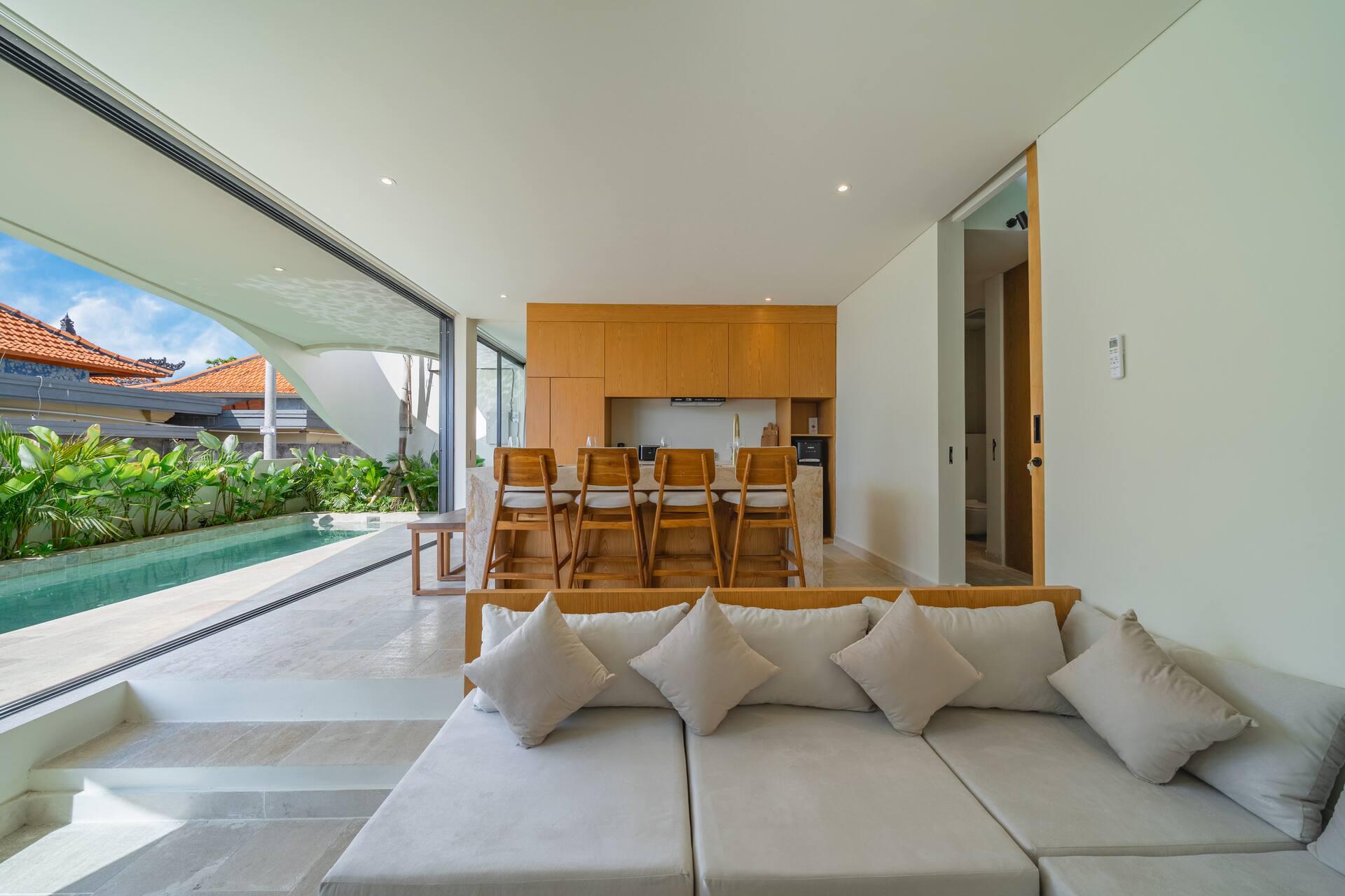 Living pavilion at Villa Aura opening onto the pool through full-height sliding glass