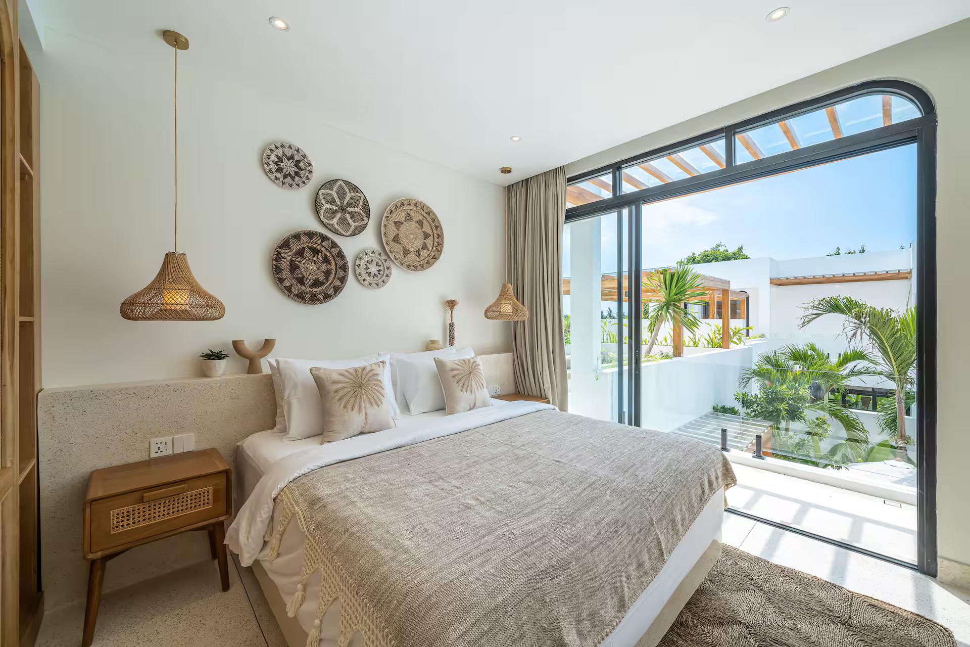 King bedroom at Bellavista Amici with woven wall discs and glass doors to the terrace