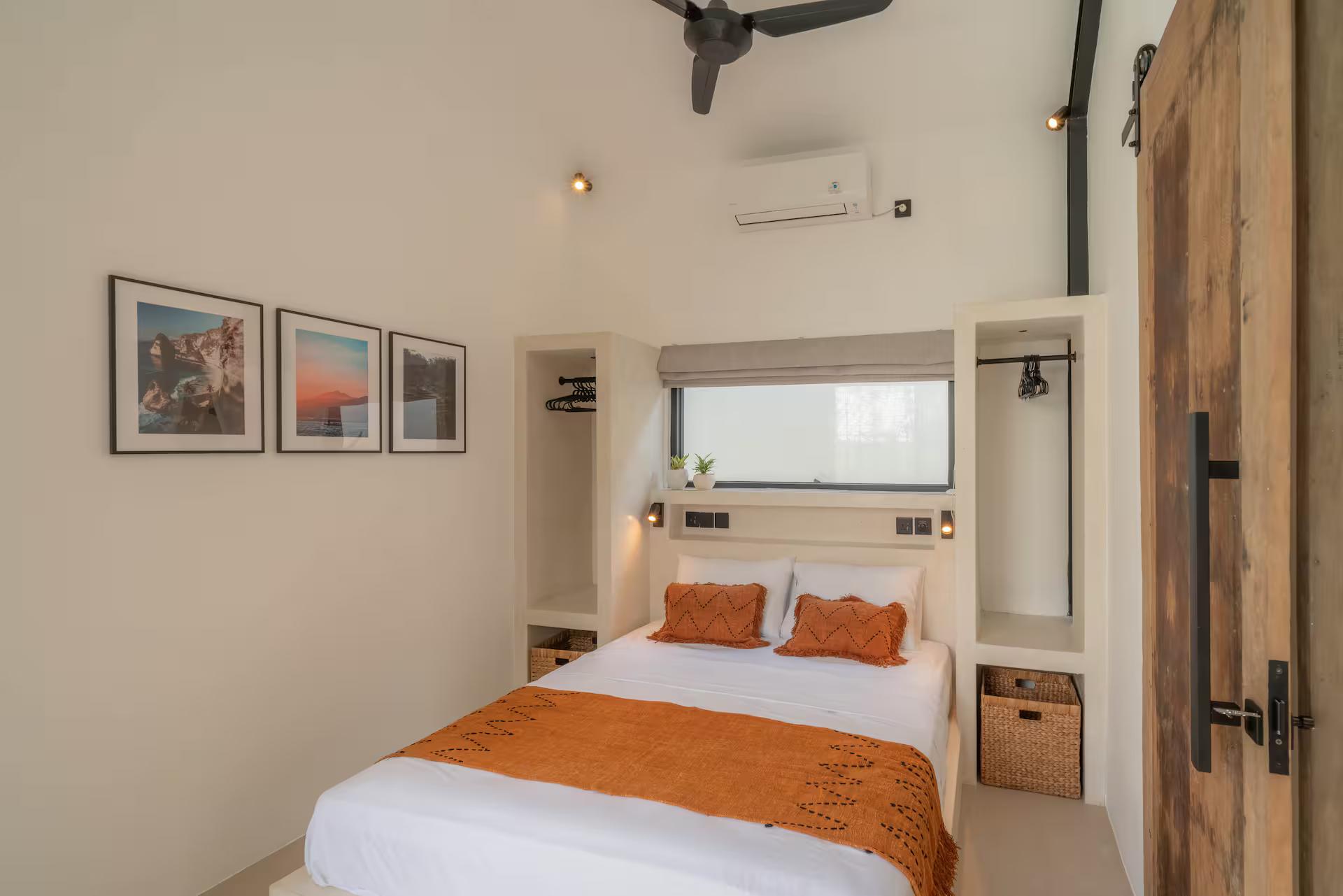 Queen bedroom at Casa Kami with a rust-orange throw and rattan baskets over the bed