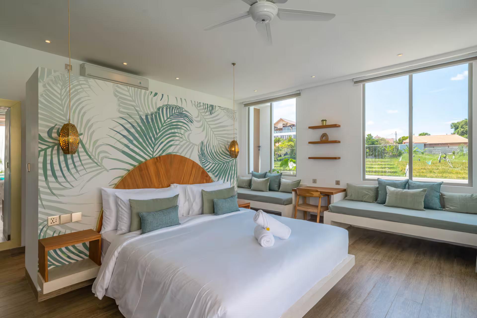 Master bedroom at Villa Vola, painted leaf mural behind an arched timber headboard