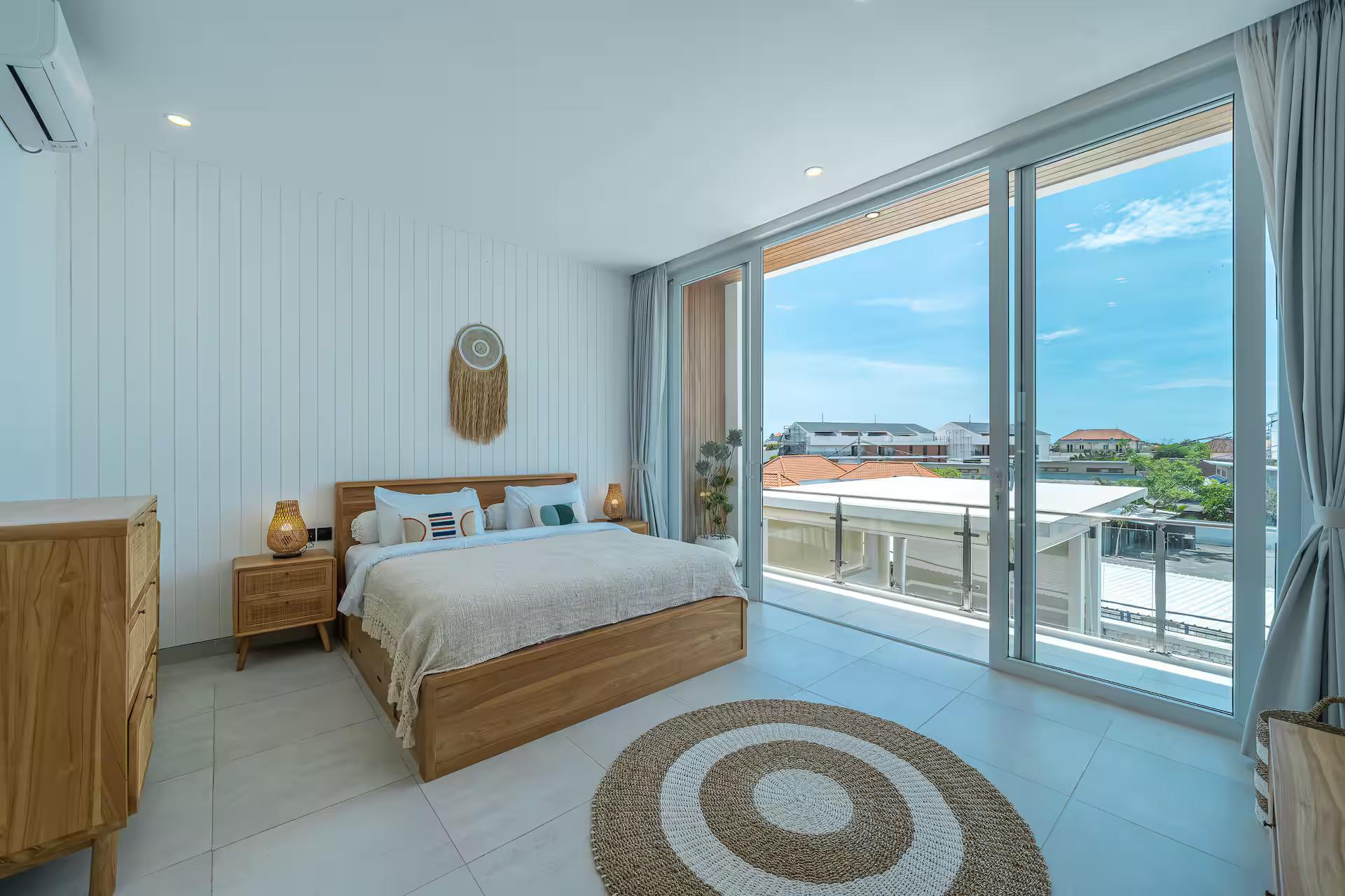 King bedroom at Villa Era with a timber bedhead and sliding glass onto a balcony