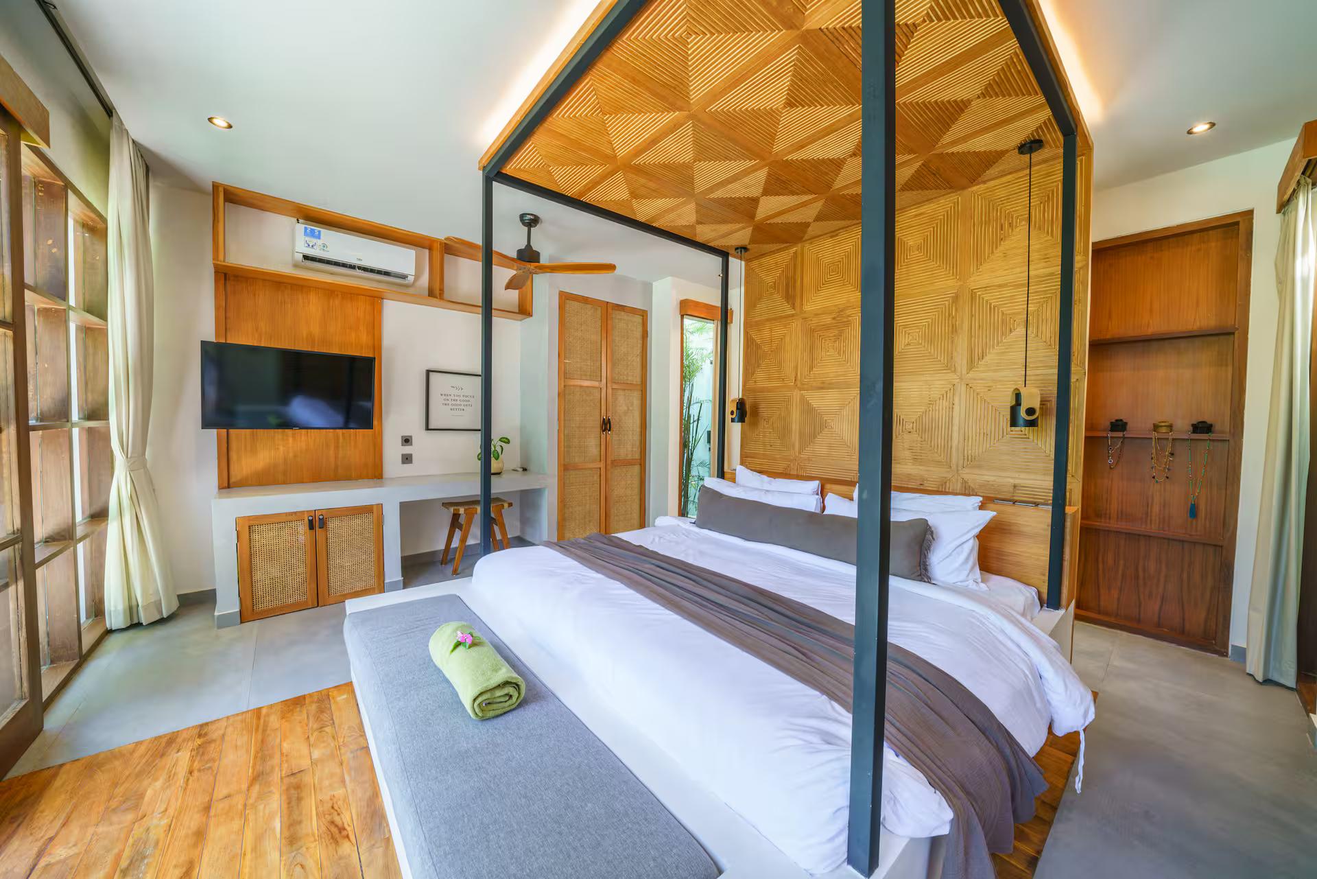 Bedroom with a black four-poster frame against a patterned timber headboard wall