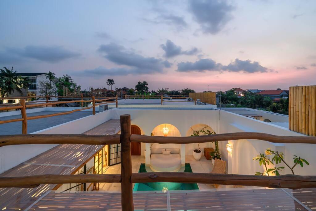 Sunset from the rooftop terrace at Villa Valeria, timber railings above the lit courtyard pool