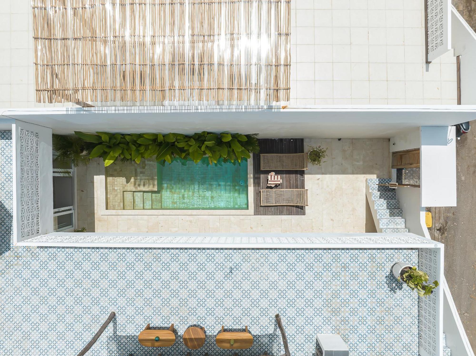 The rooftop terrace with its sunken green-tiled tub and split-reed screen above the courtyard