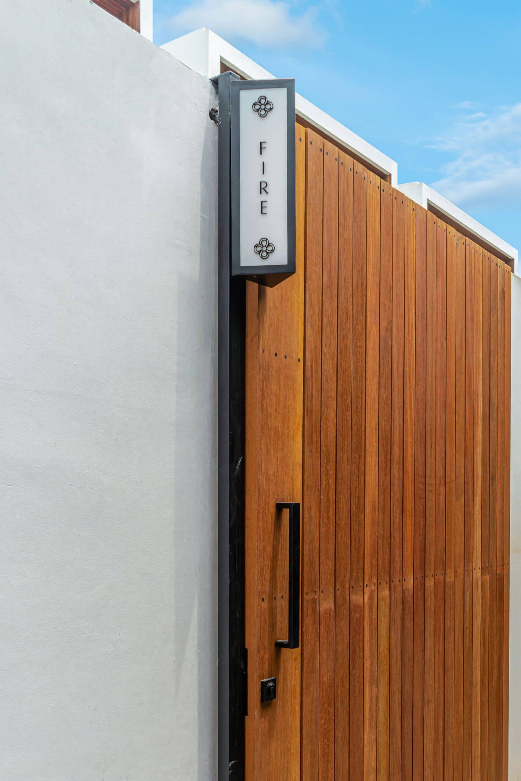 The villa's own timber entrance gate at Hidden Elements, with its FIRE nameplate