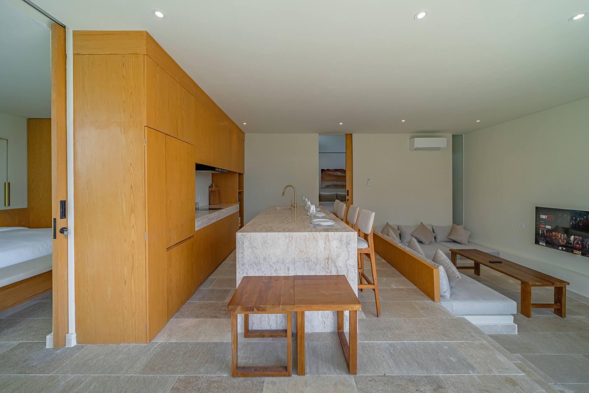 Open-plan kitchen, dining and living space at Villa Aura under a vaulted white ceiling