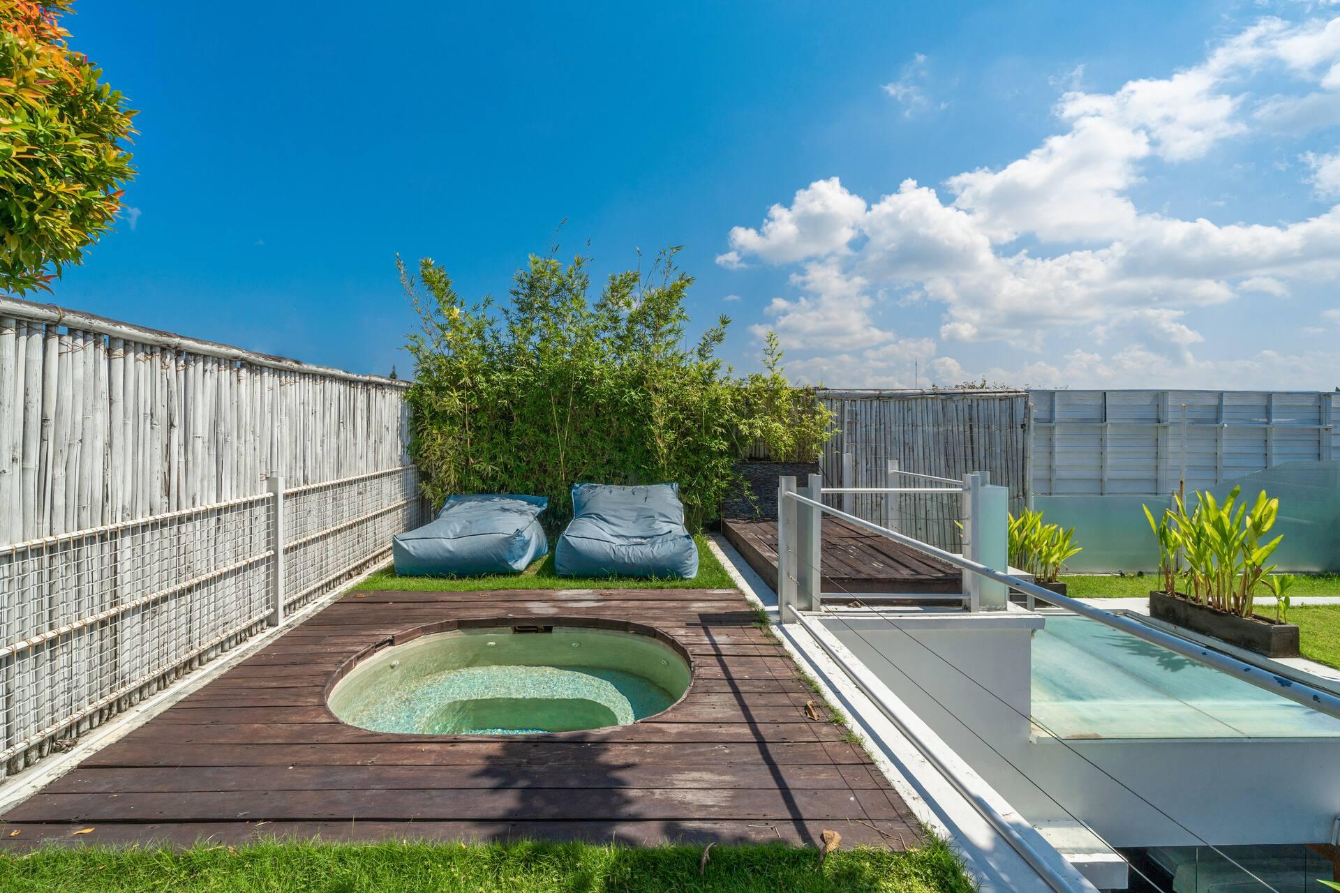Round plunge pool, lawn and beanbags on the rooftop terrace at Villa Tykhe