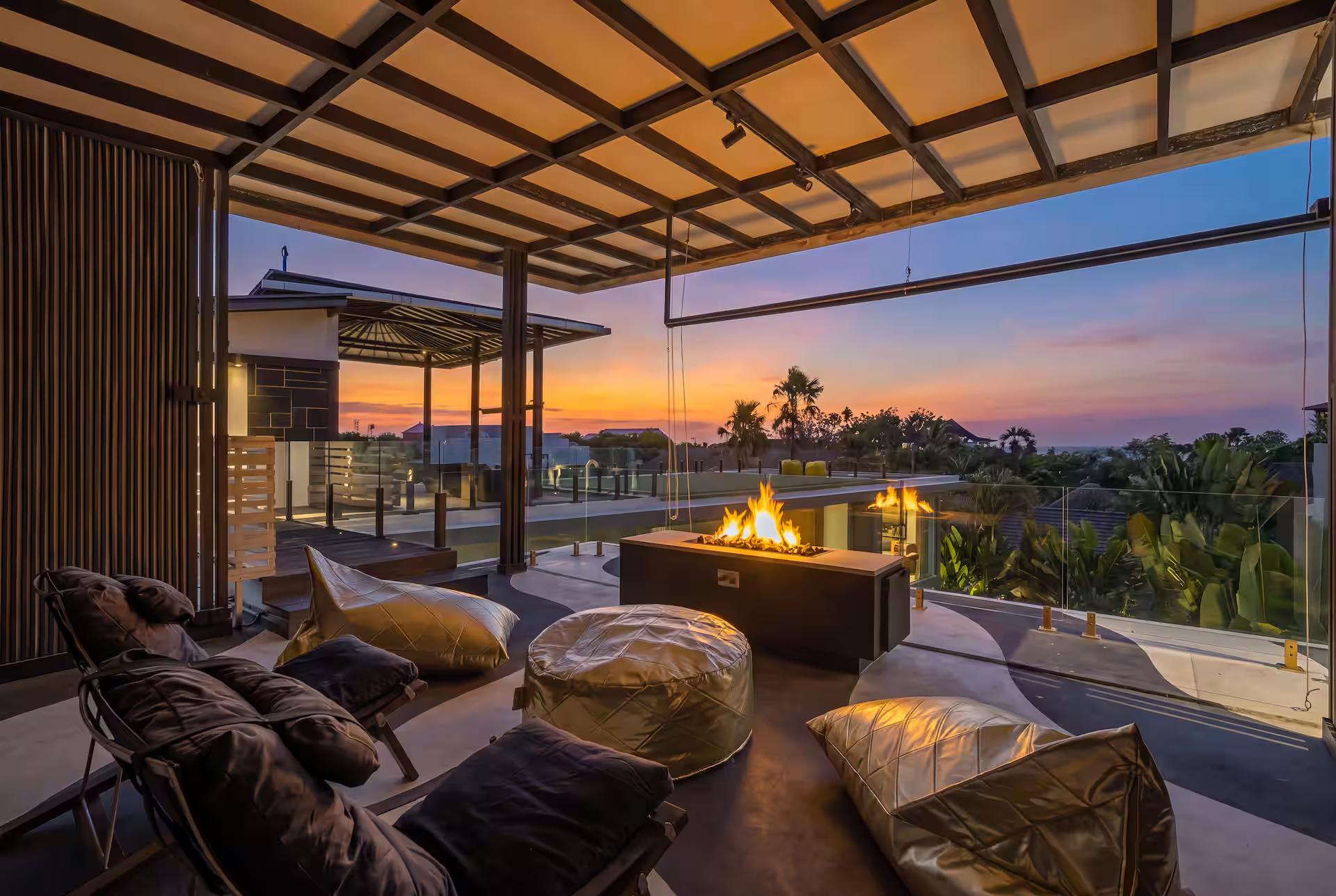 Rooftop lounge at sunset, beanbags drawn up around the long gas fire table