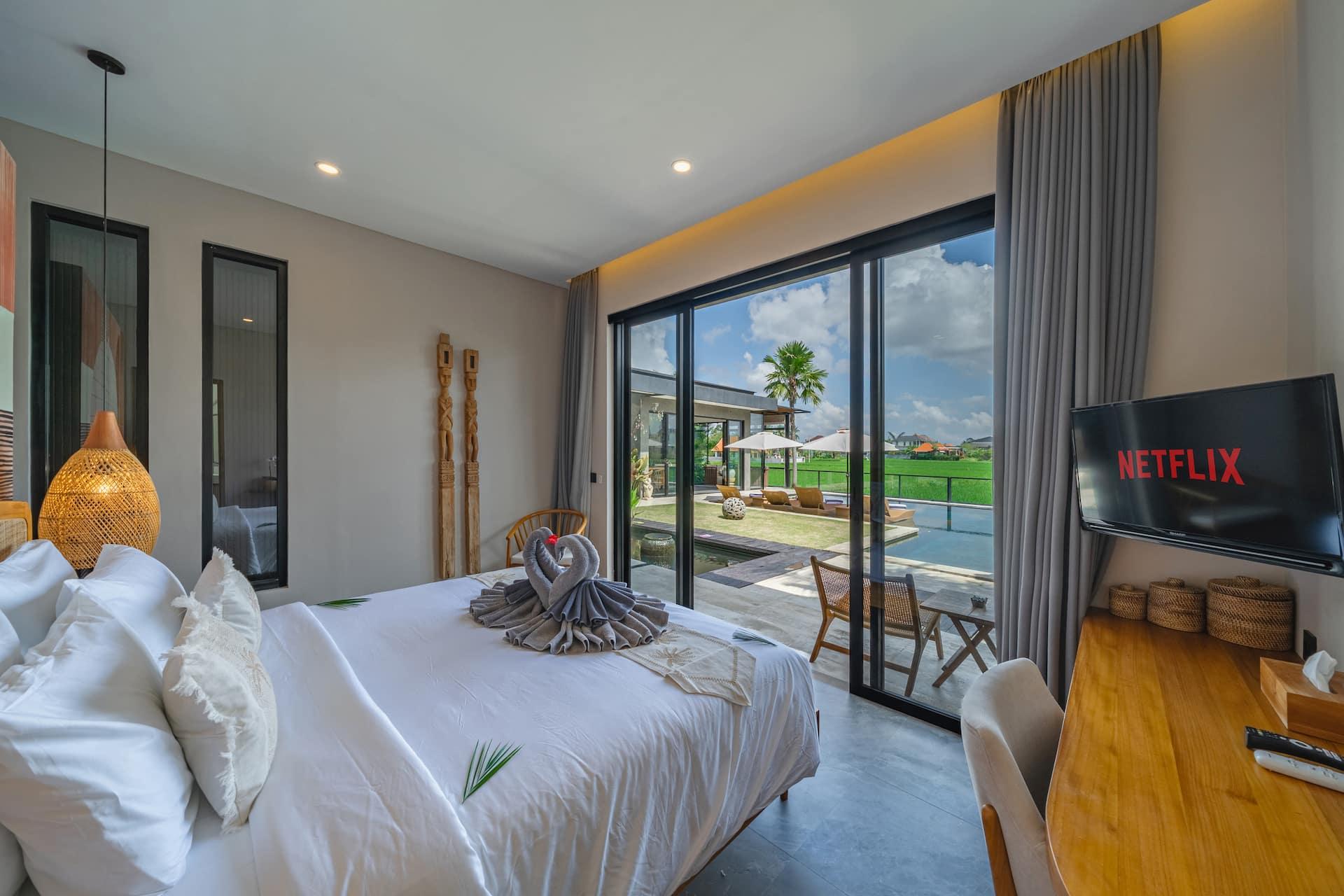 Master bedroom at Villa Bliss, king bed and terracotta arc mural, sliding glass open to the pool