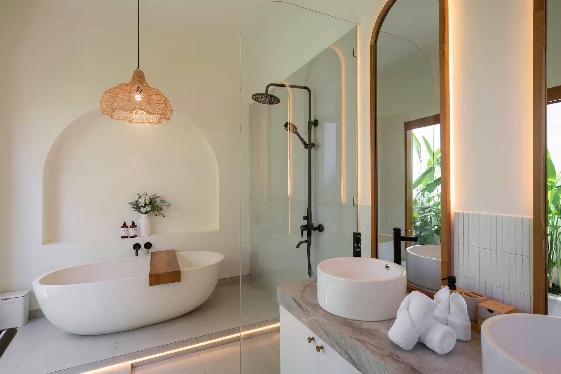 Freestanding tub and a dark rainfall shower in the en-suite at Villa Yuri