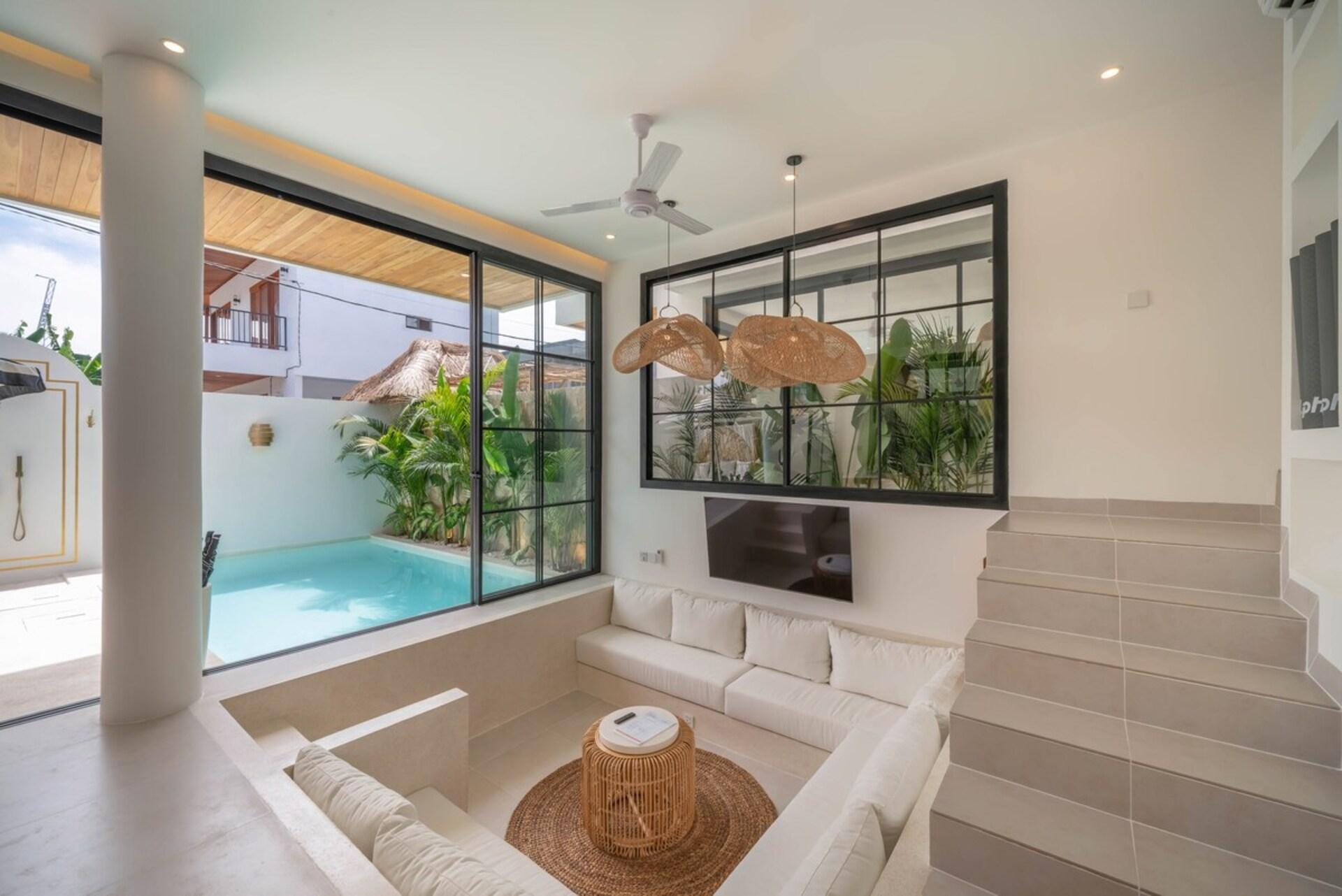 The lounge looking out through black steel-framed glass to the pool courtyard