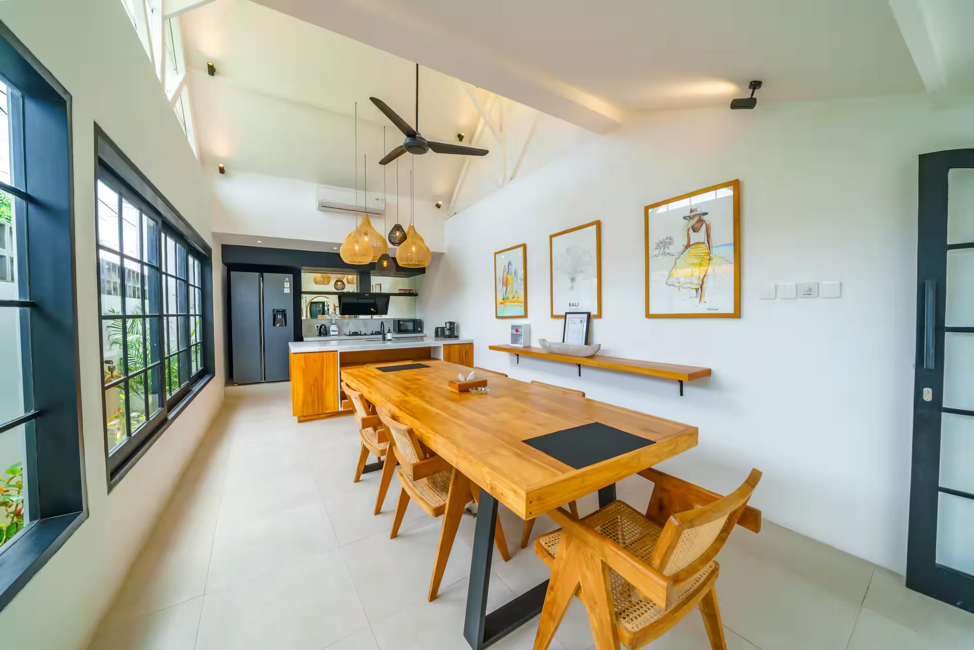 A single pale timber slab seats eight at Villa Mellow, cane chairs down both sides