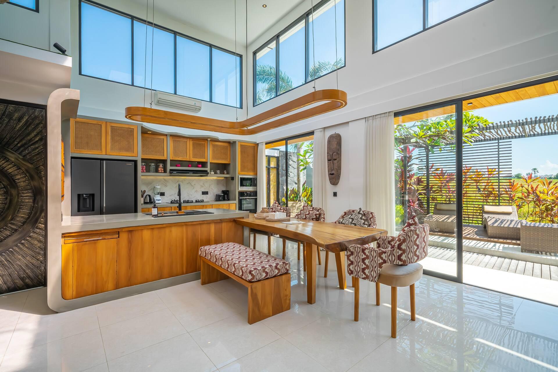 Kitchen in warm timber with a live-edge dining counter, rice fields through the glass beyond