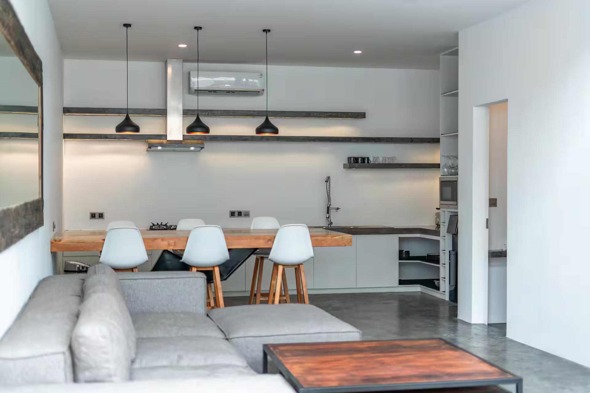 Galley kitchen in white and concrete seen across the sectional at Loft Carolyn 2
